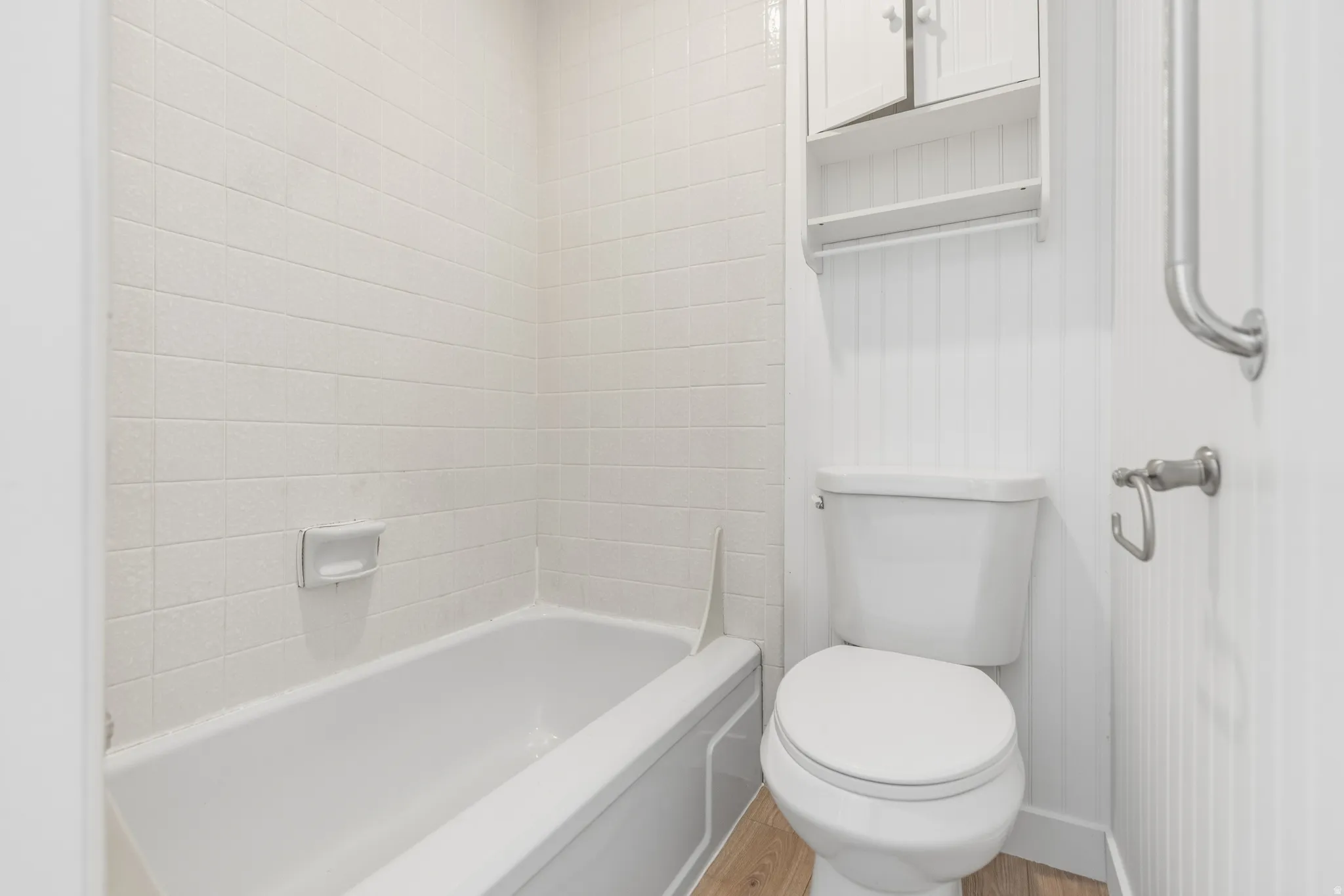 Bathroom featuring light wood-style flooring and bathtub / shower combination
