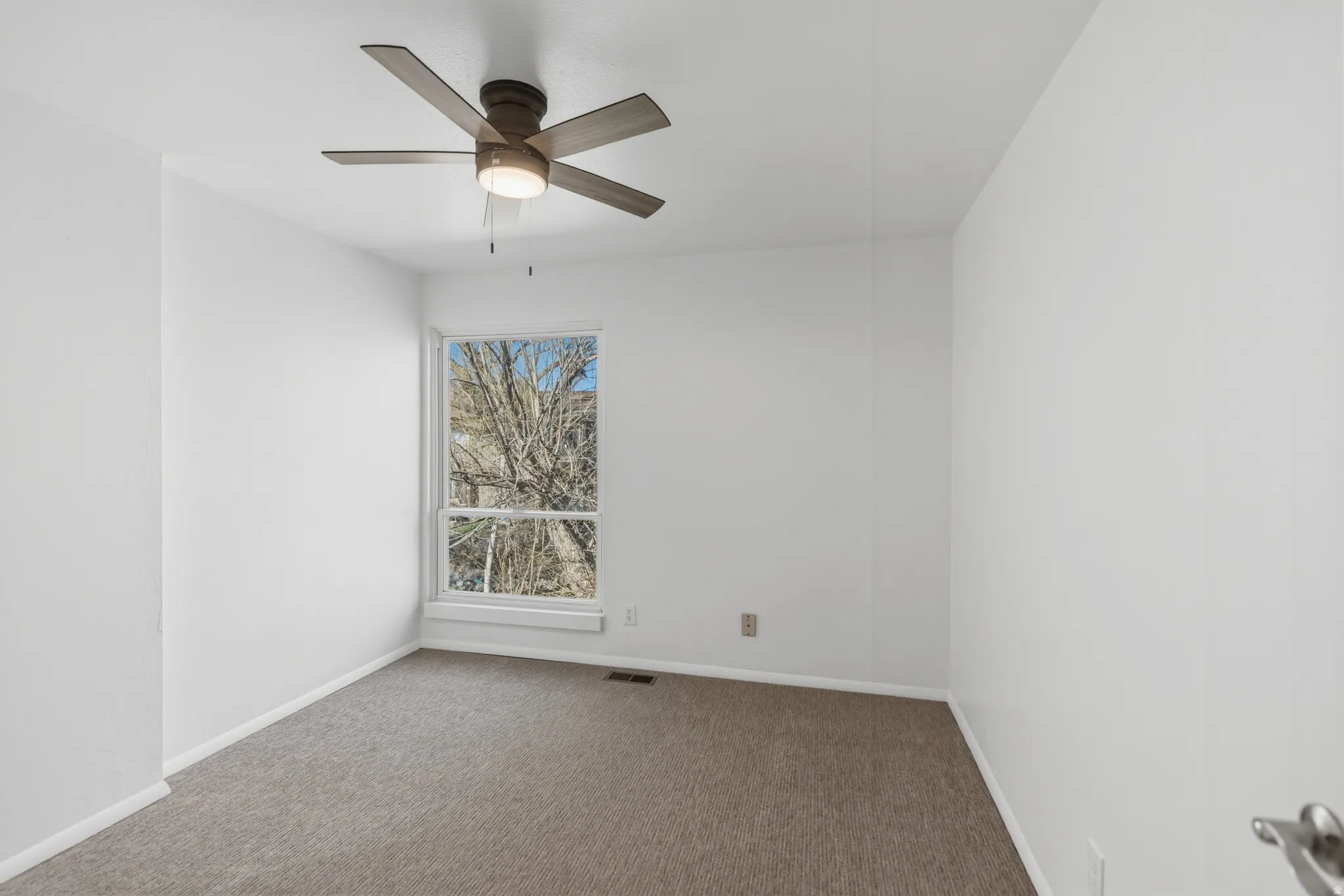 Unfurnished room featuring ceiling fan and carpet floors