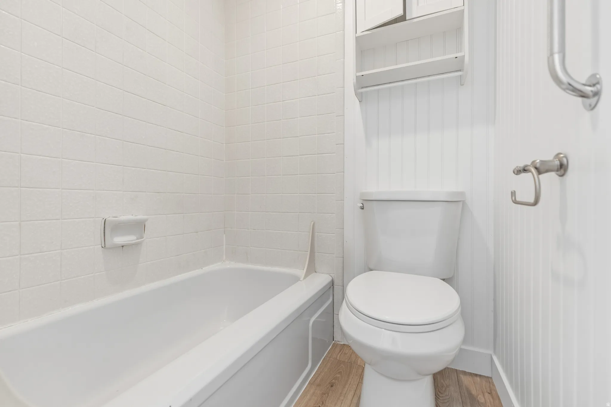 Bathroom featuring light wood-style floors and bathtub / shower combination