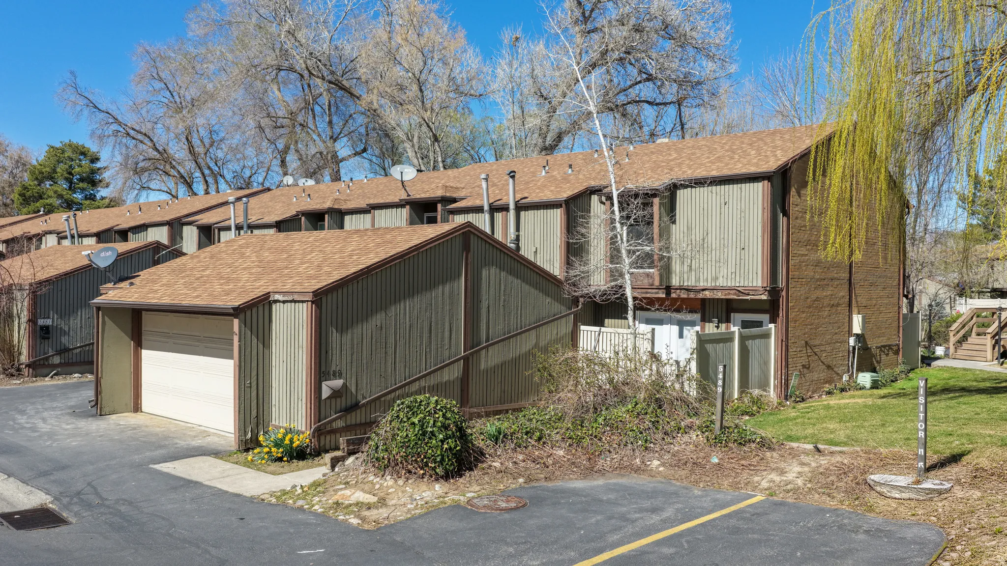 View of front facade with roof with shingles, a garage, and an outdoor structure