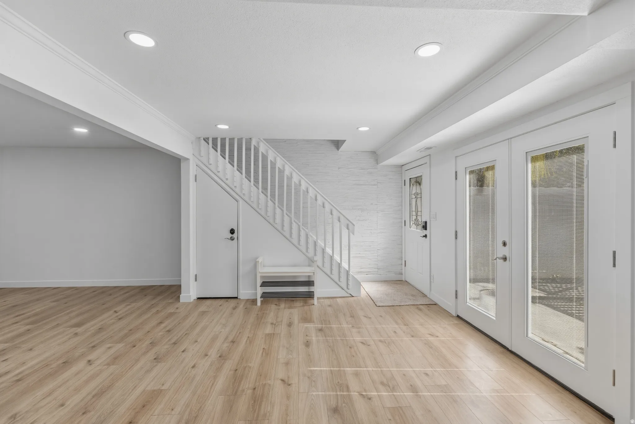 Foyer entrance featuring light wood-type flooring, french doors, and recessed lighting
