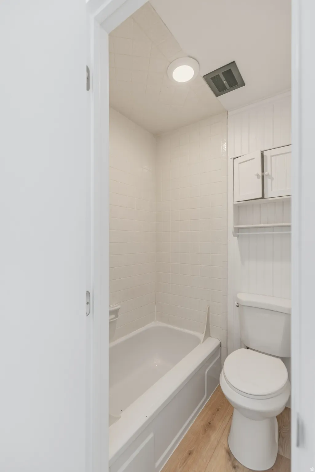 Full bathroom featuring light wood-style floors and shower / washtub combination