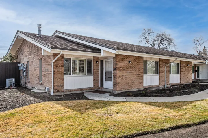 Ranch-style home featuring a front yard, brick siding, and covered porch