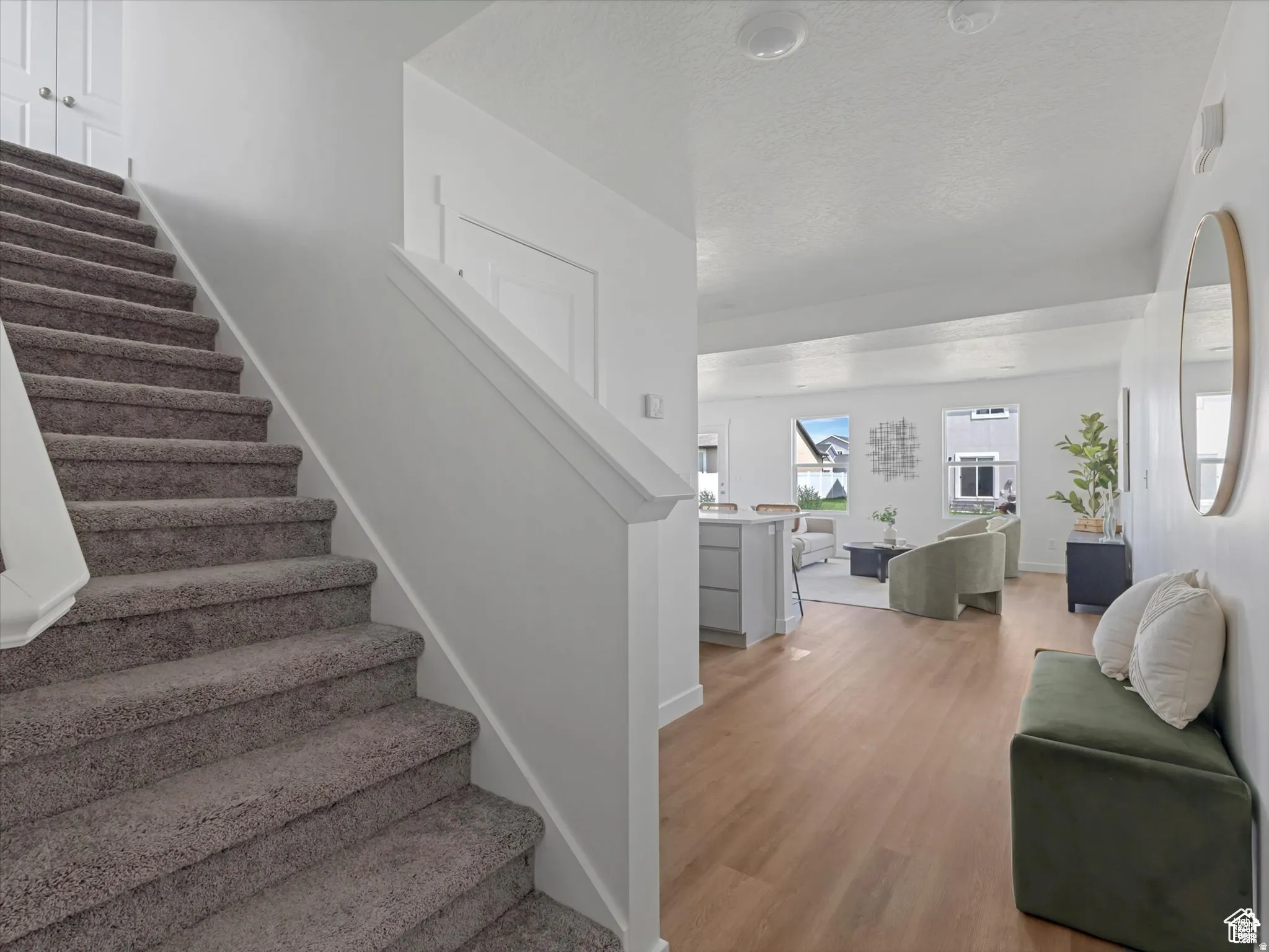 Stairway featuring wood finished floors and a textured ceiling