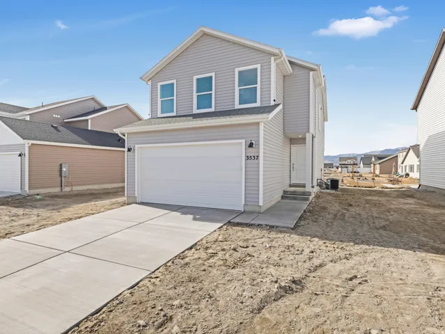 Traditional-style home with concrete driveway and an attached garage