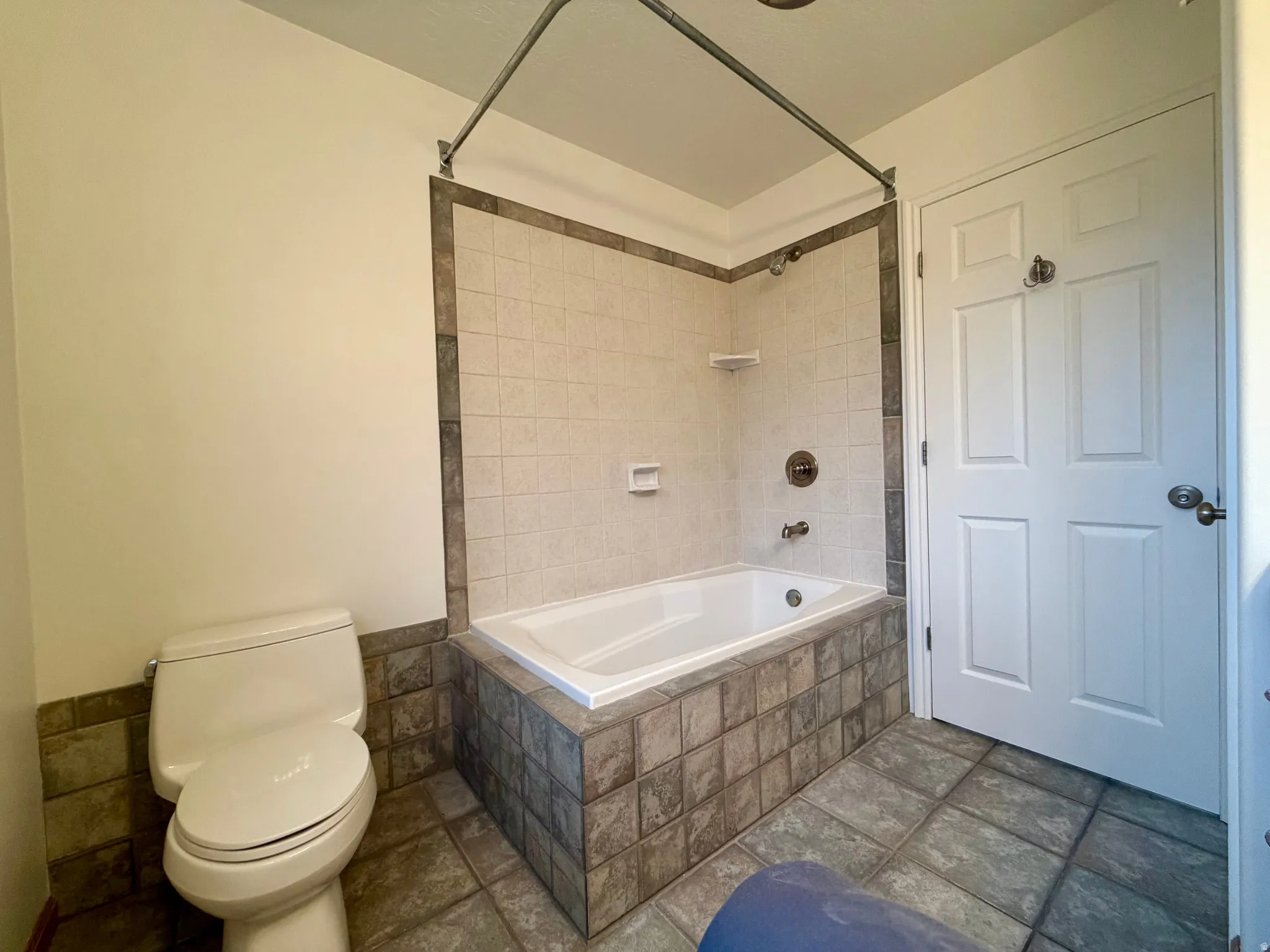 Premier bedroom's bathroom with craftsman tiled shower / bath combo and tile walls