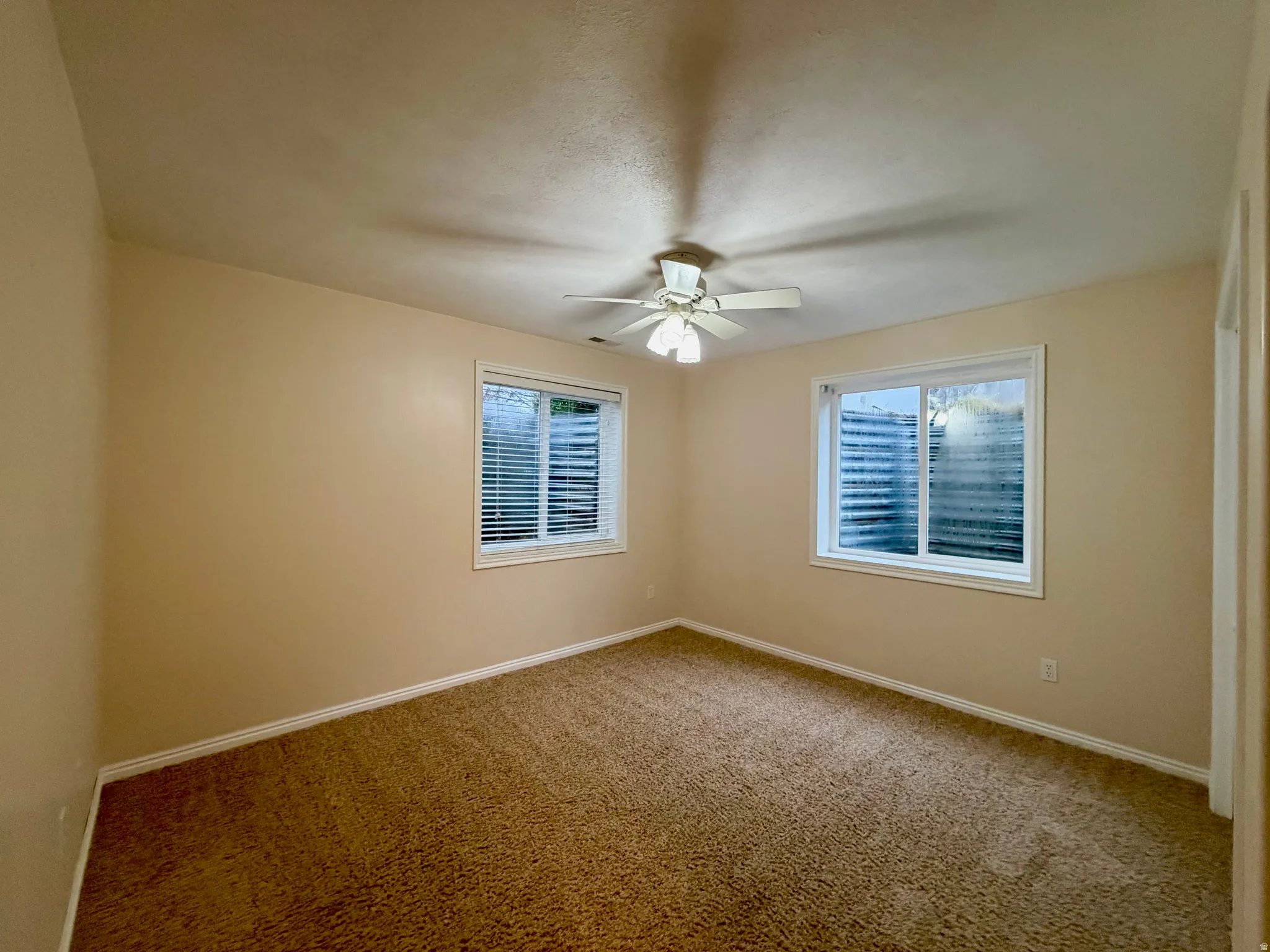 bedroom with light colored carpet, healthy amount of natural light, closet and ceiling fan