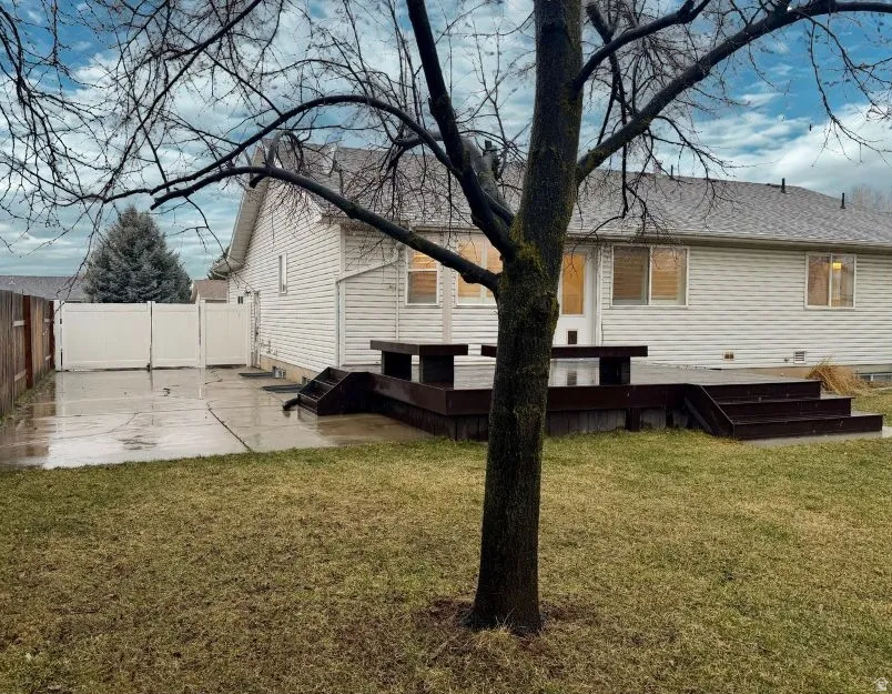 Rear view of property including parking pad for RV or other needs with a fenced backyard, a deck, a patio, and a shingled roof