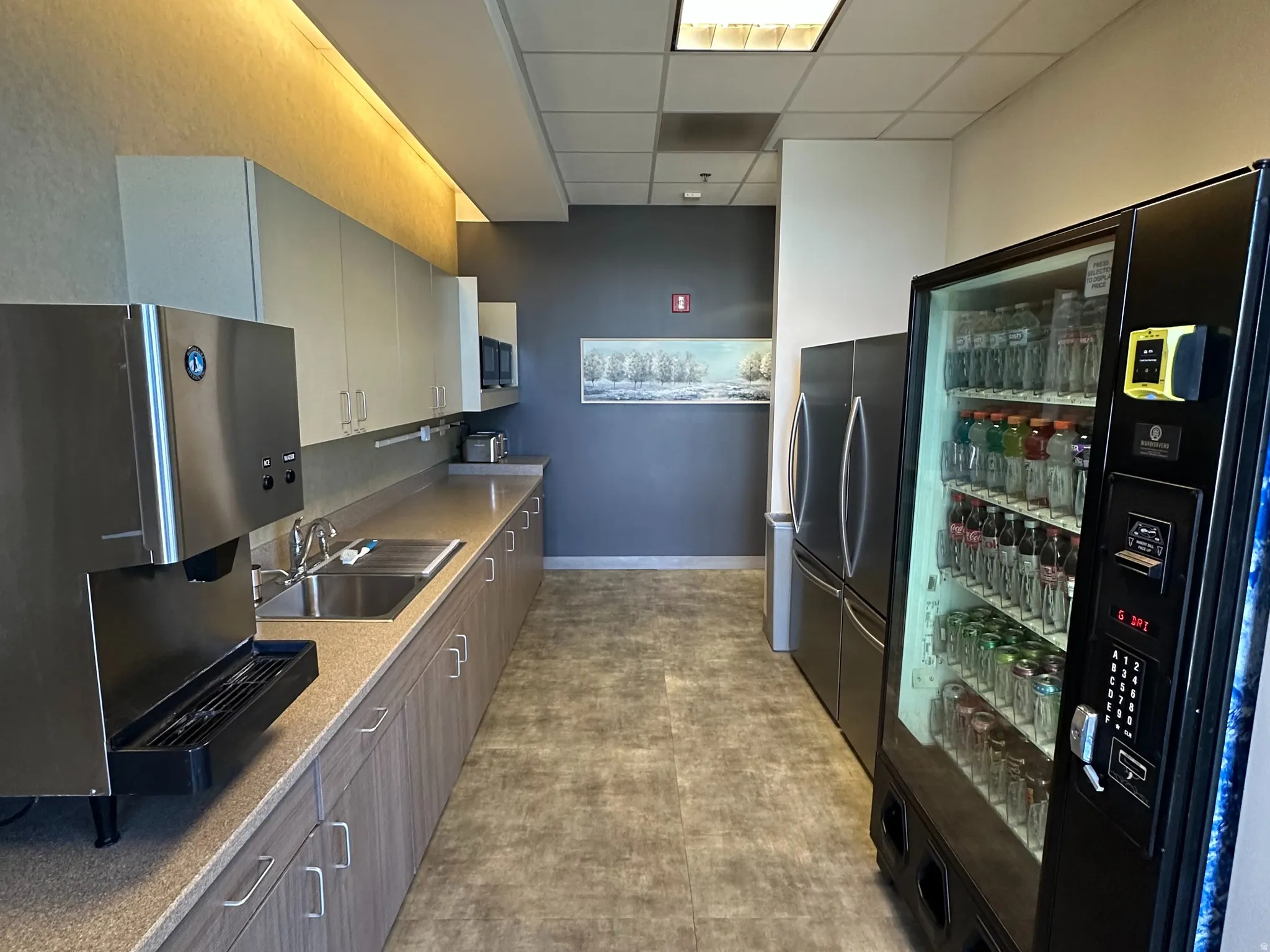 Kitchen with a paneled ceiling and freestanding refrigerator