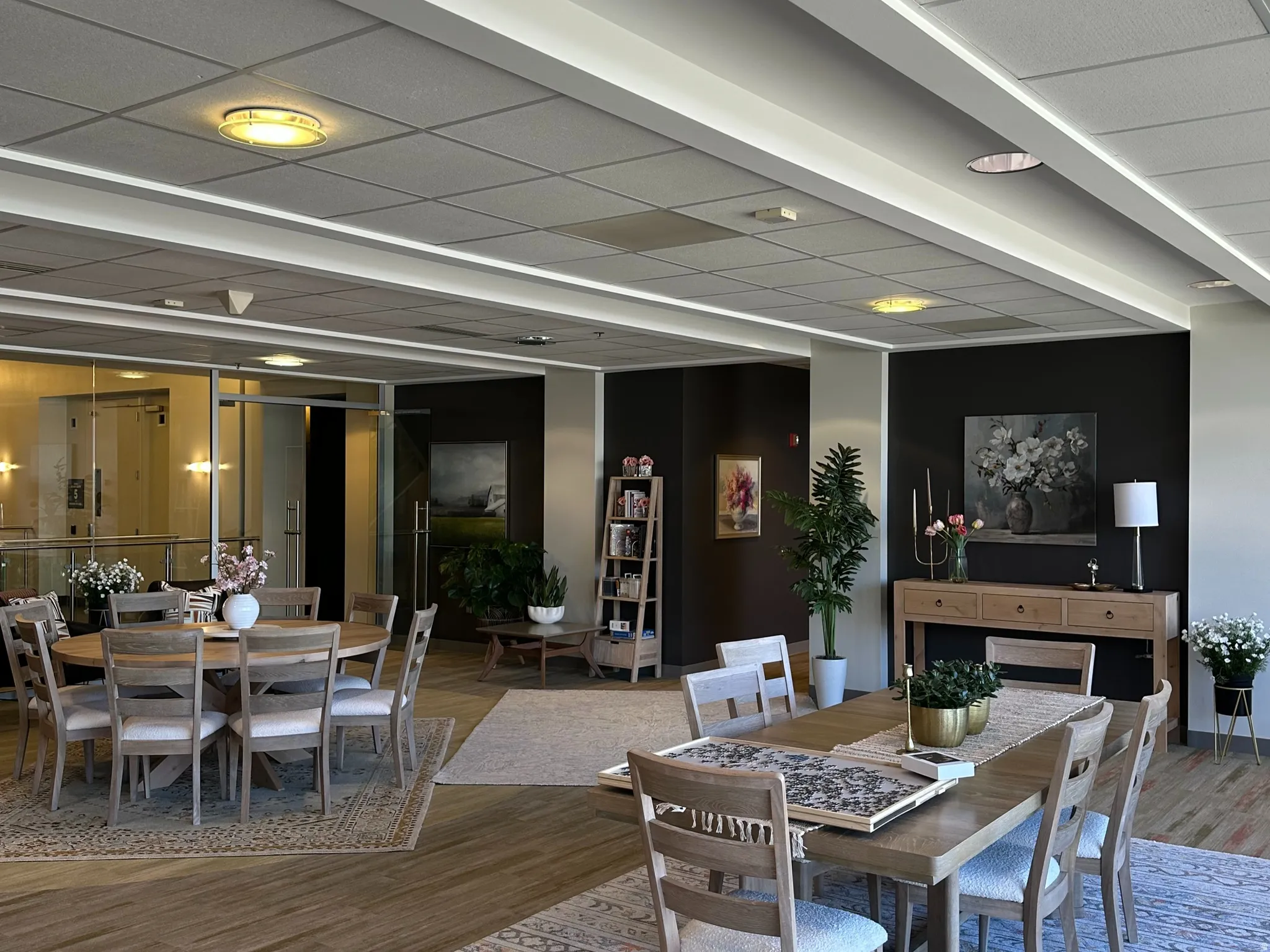 Break area with a drop ceiling, wood finished floors, and expansive windows