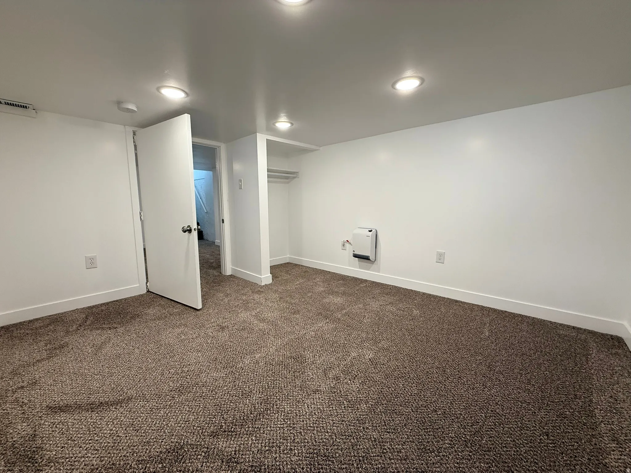 Finished below grade area with baseboards and dark colored carpet