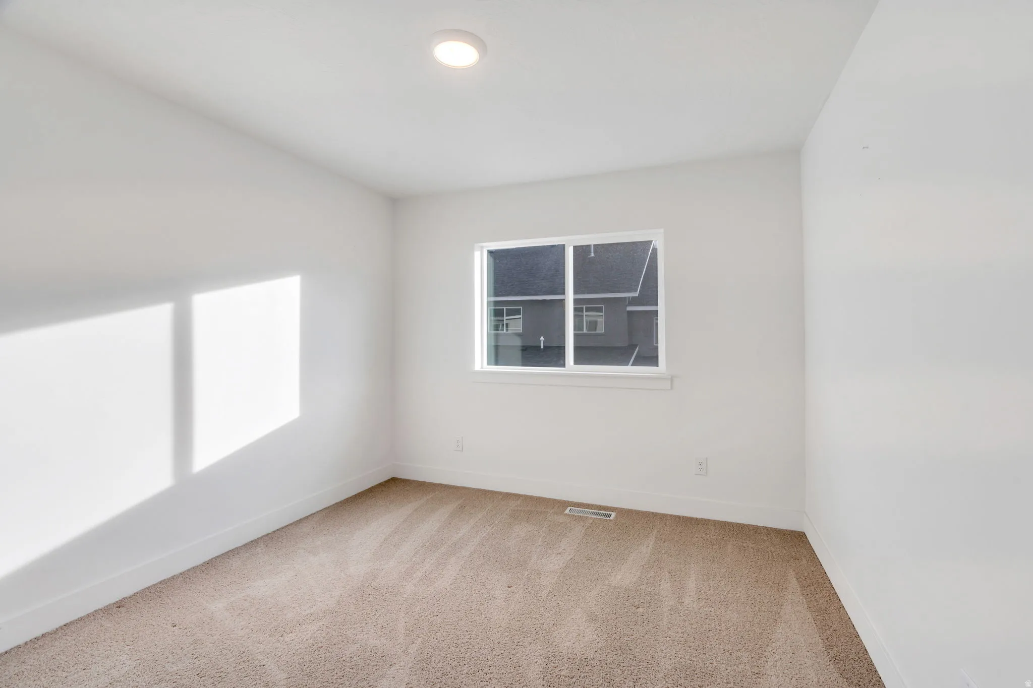 Spare room with light carpet and baseboards