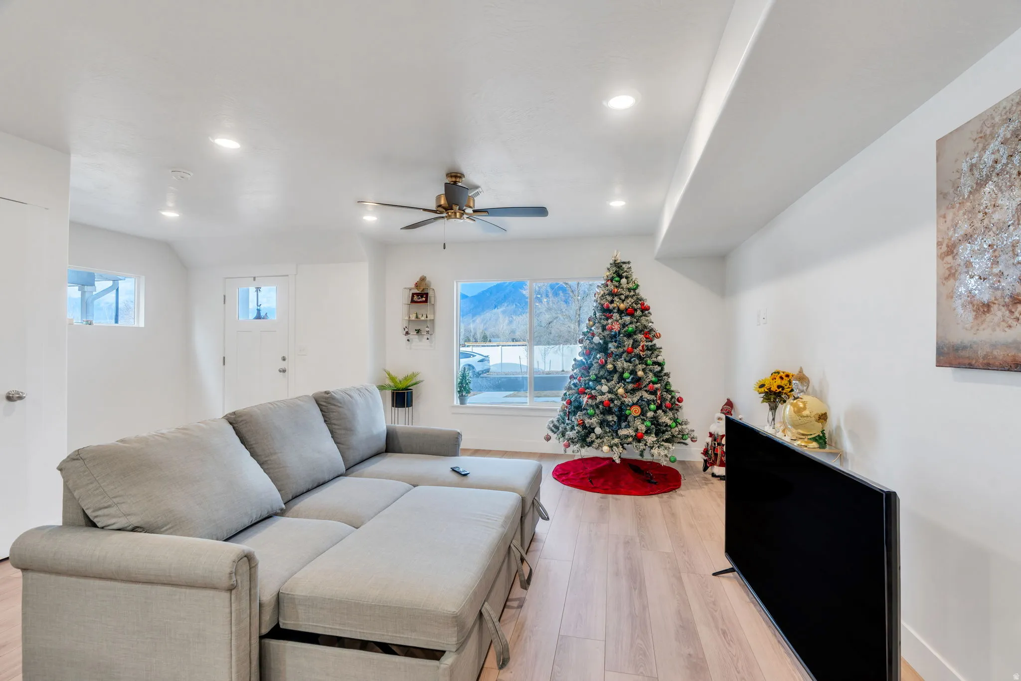 Living area featuring light wood-type flooring, a ceiling fan, and recessed lighting