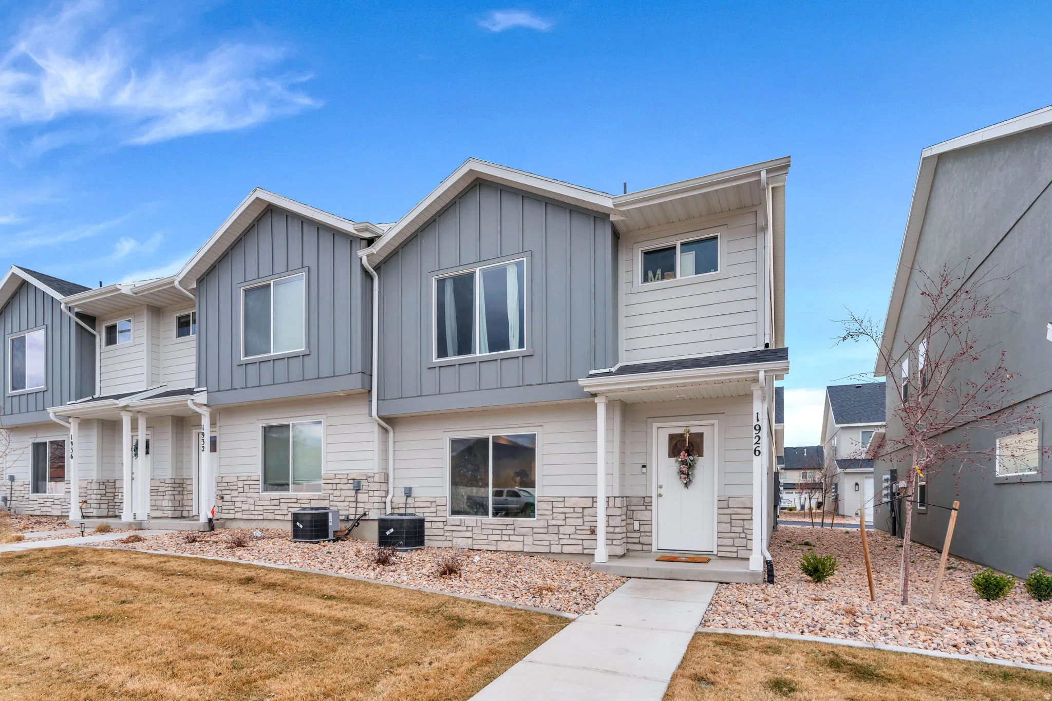 View of front of home with stone siding, board and batten siding, and a front lawn