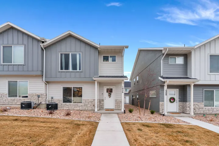 View of front of property featuring stone siding, board and batten siding, and a front lawn