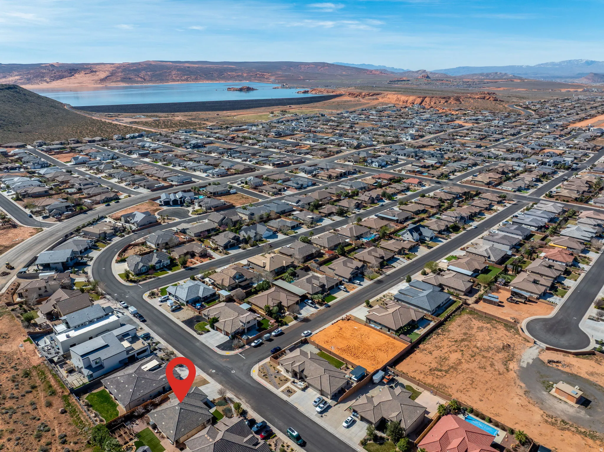 Aerial view of property and surrounding area with a water and mountain view and nearby suburban area