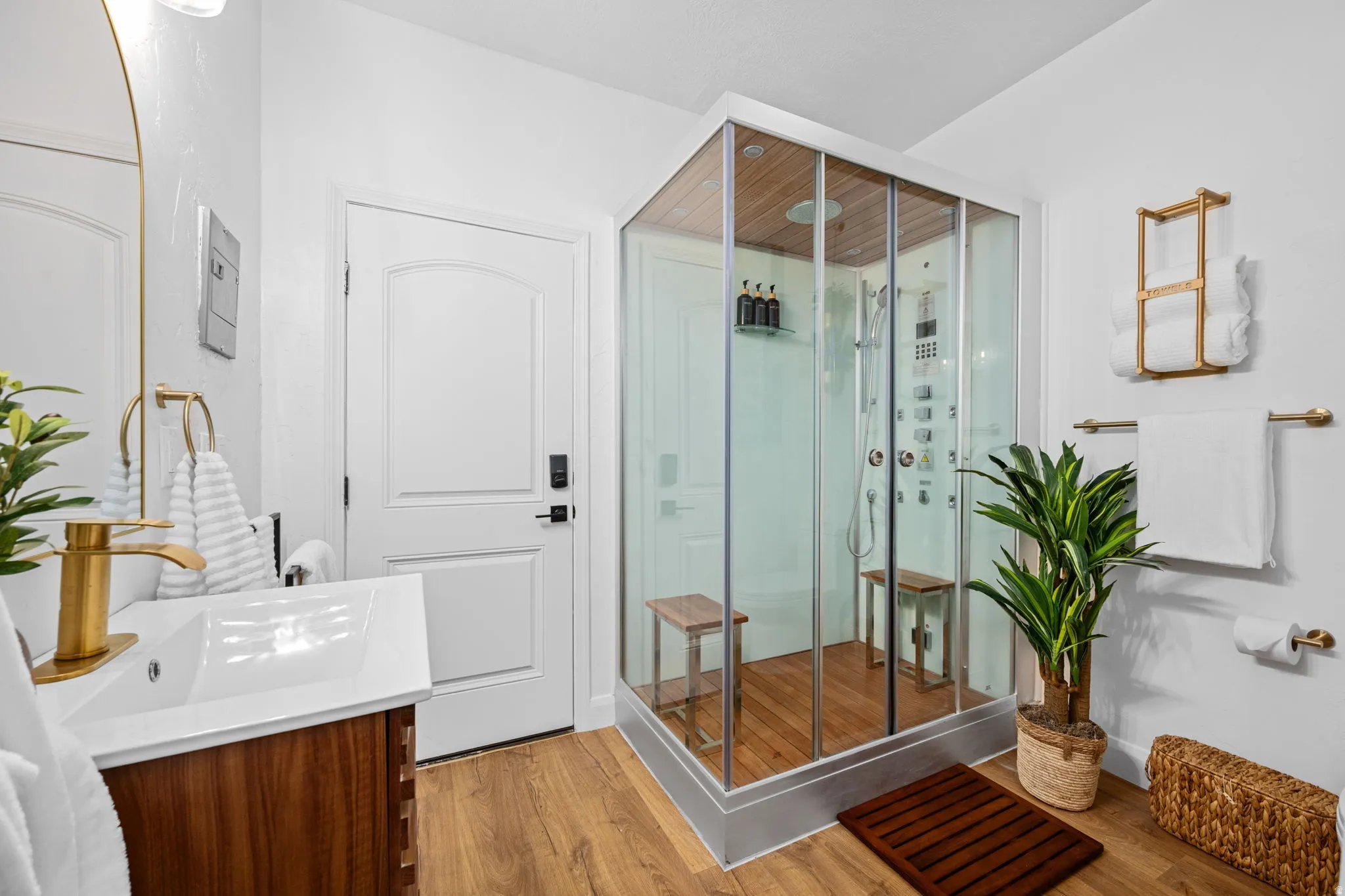 Full bathroom with a stall shower, vanity, and light wood-type flooring