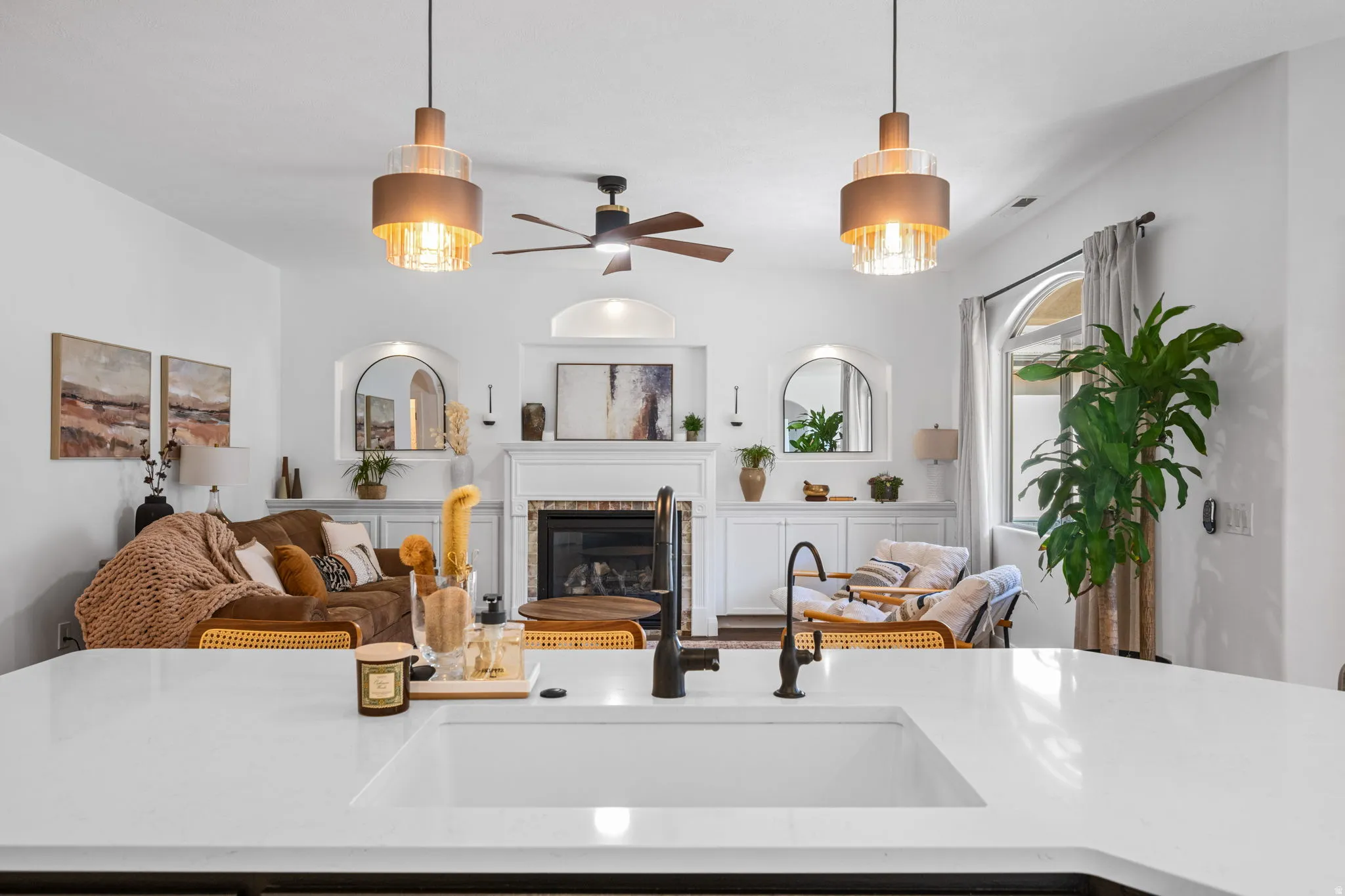 Living area featuring a glass covered fireplace and a ceiling fan