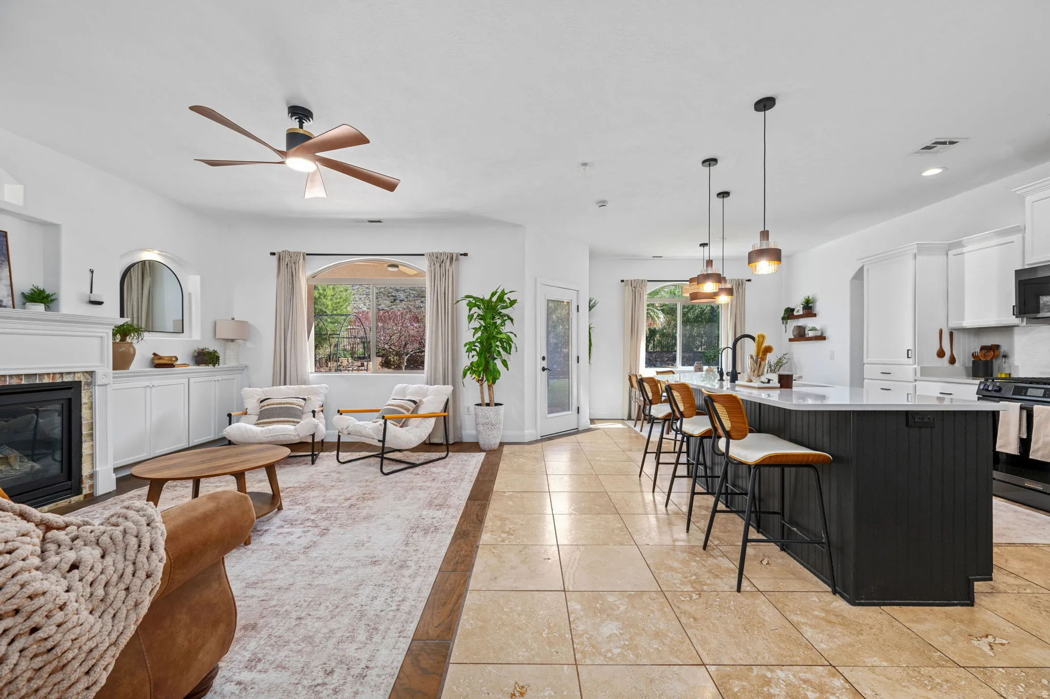 Living area with a ceiling fan, a brick fireplace, light tile patterned flooring, and recessed lighting