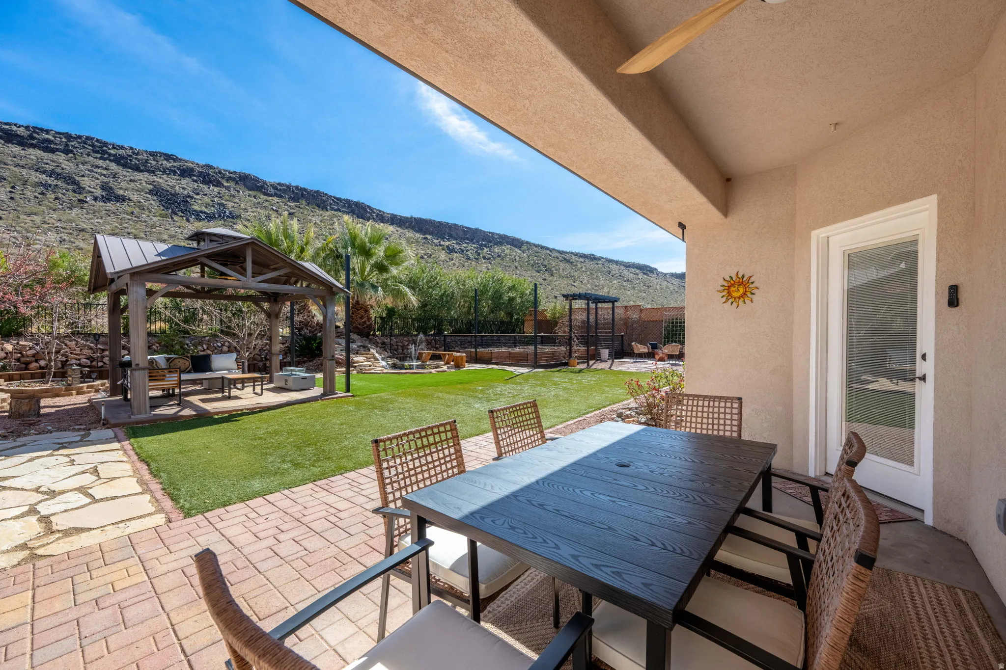 Fenced backyard with a patio, outdoor dining area, a mountain view, and a gazebo