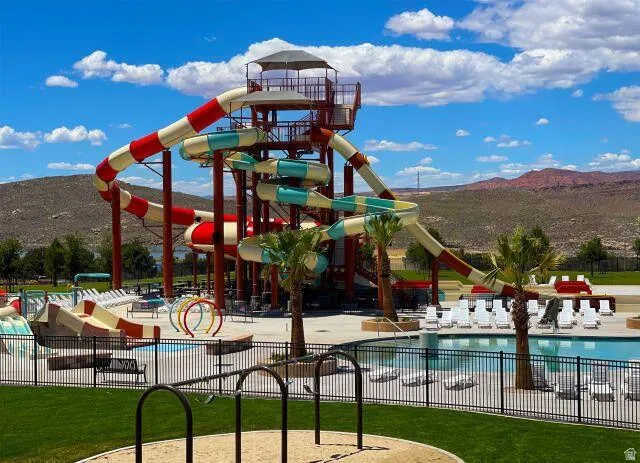 Community play area featuring a community pool, a mountain view, a patio, and a water play area