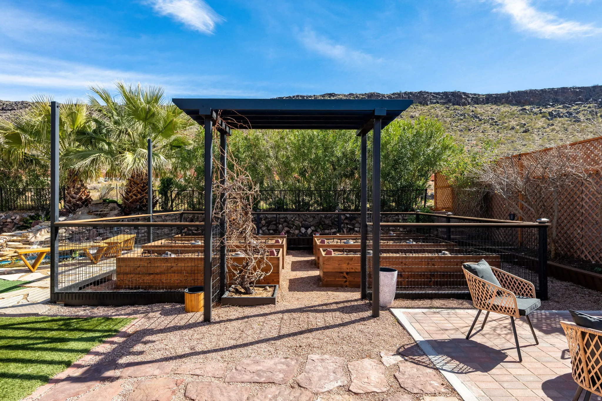 Fenced backyard featuring a vegetable garden and a patio area