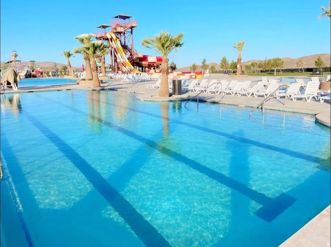 Community pool with a patio and a water slide