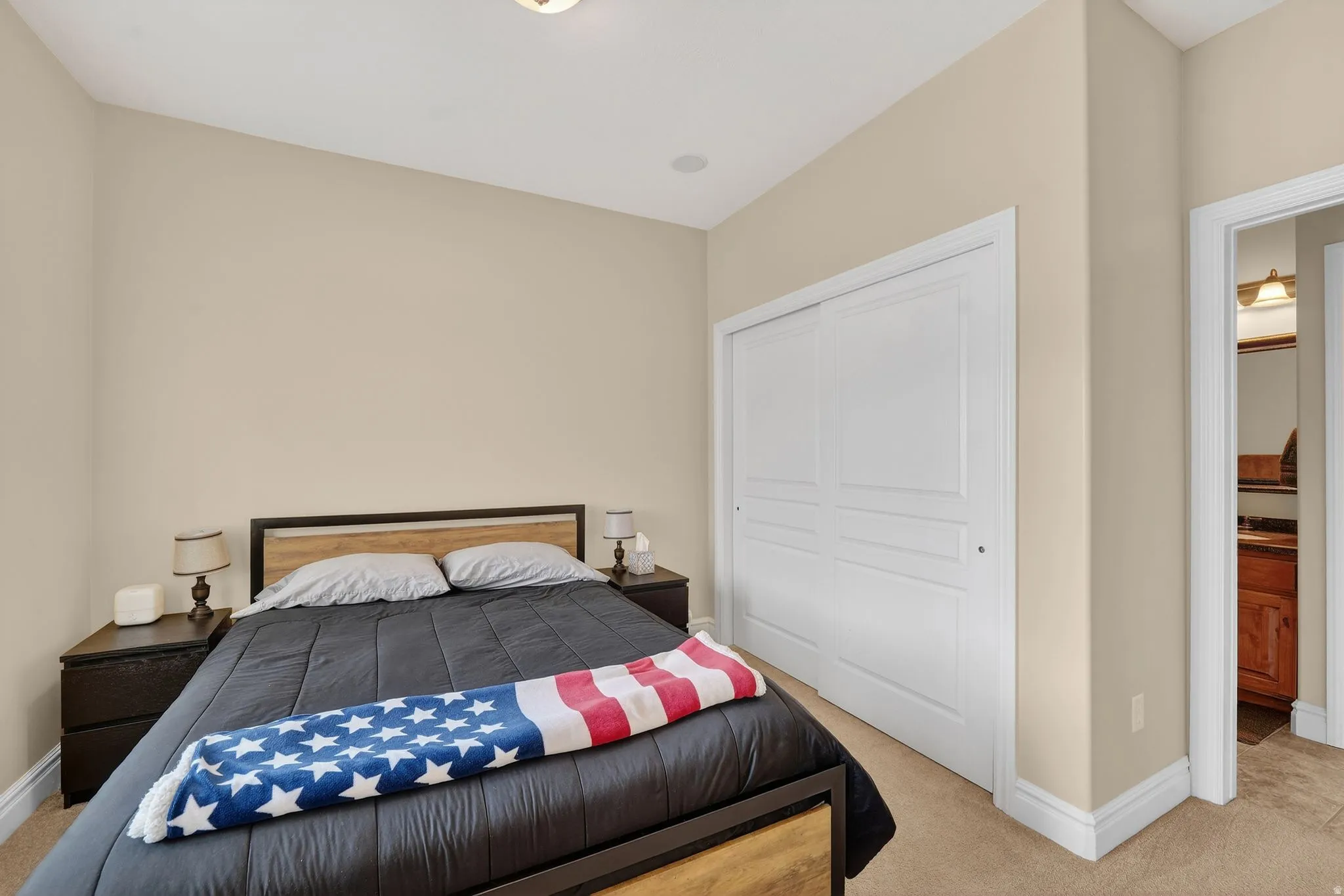 Bedroom with light carpet and a closet