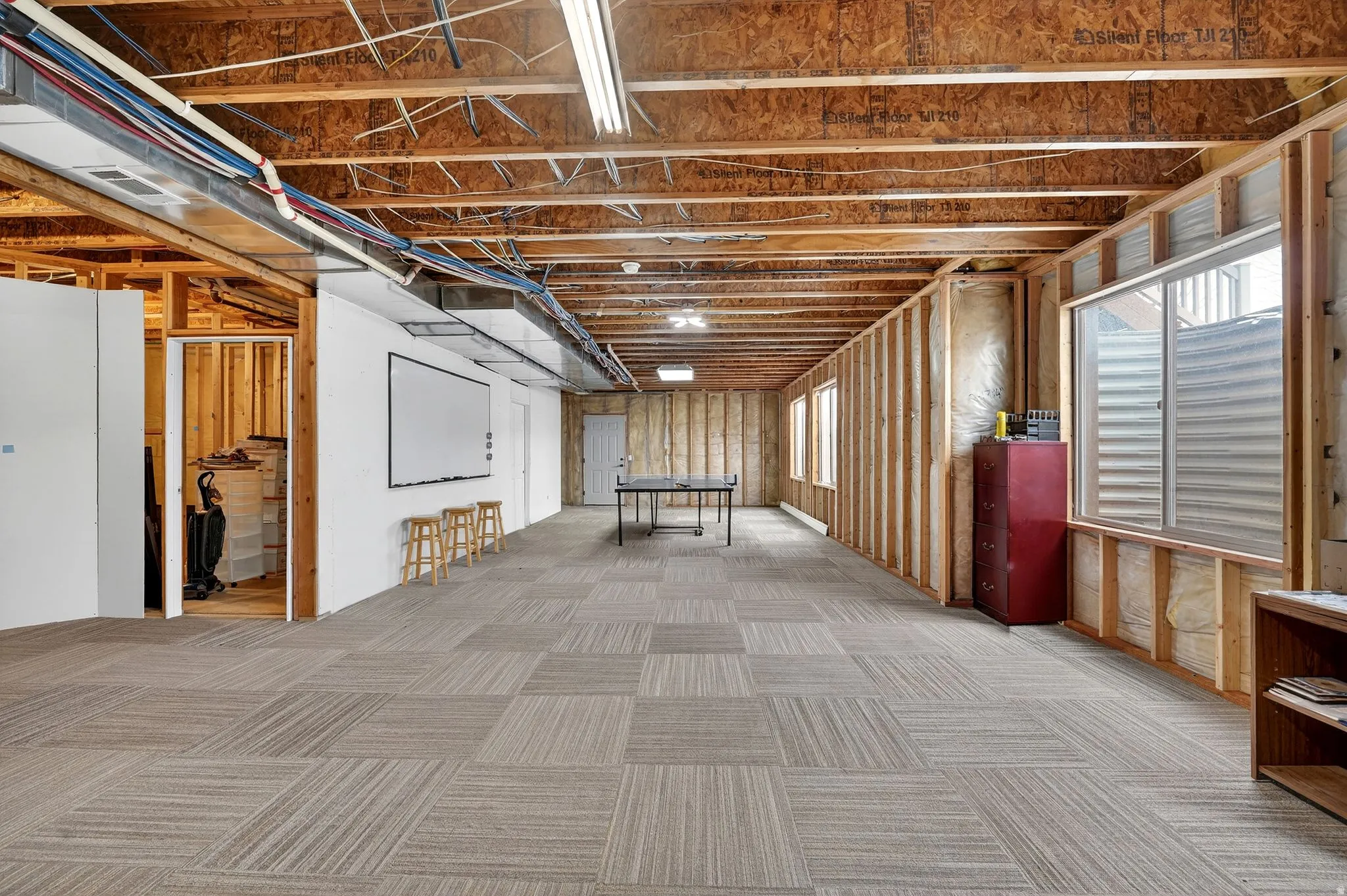 Basement featuring light colored carpet