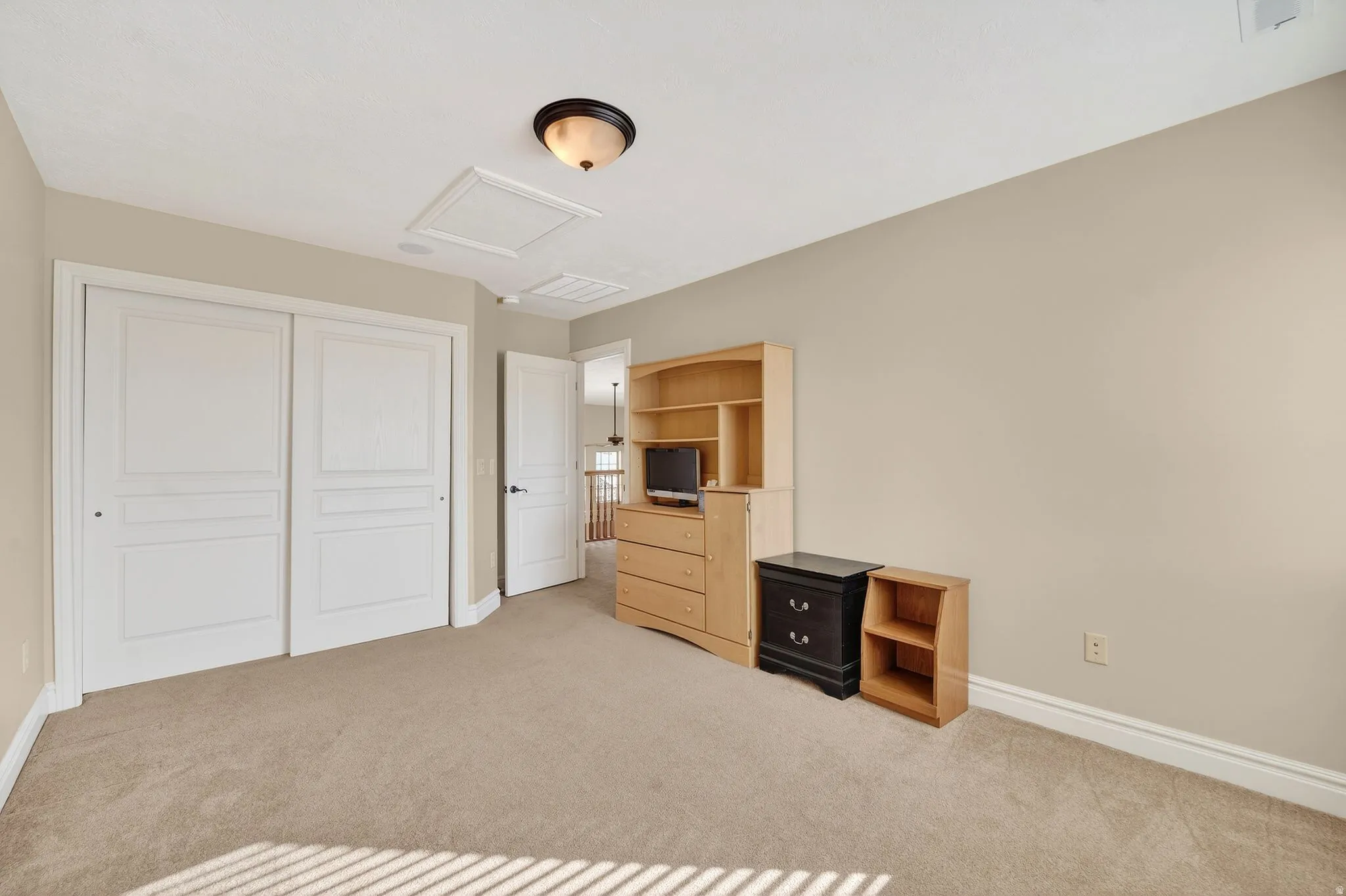 Unfurnished bedroom with light carpet and a closet