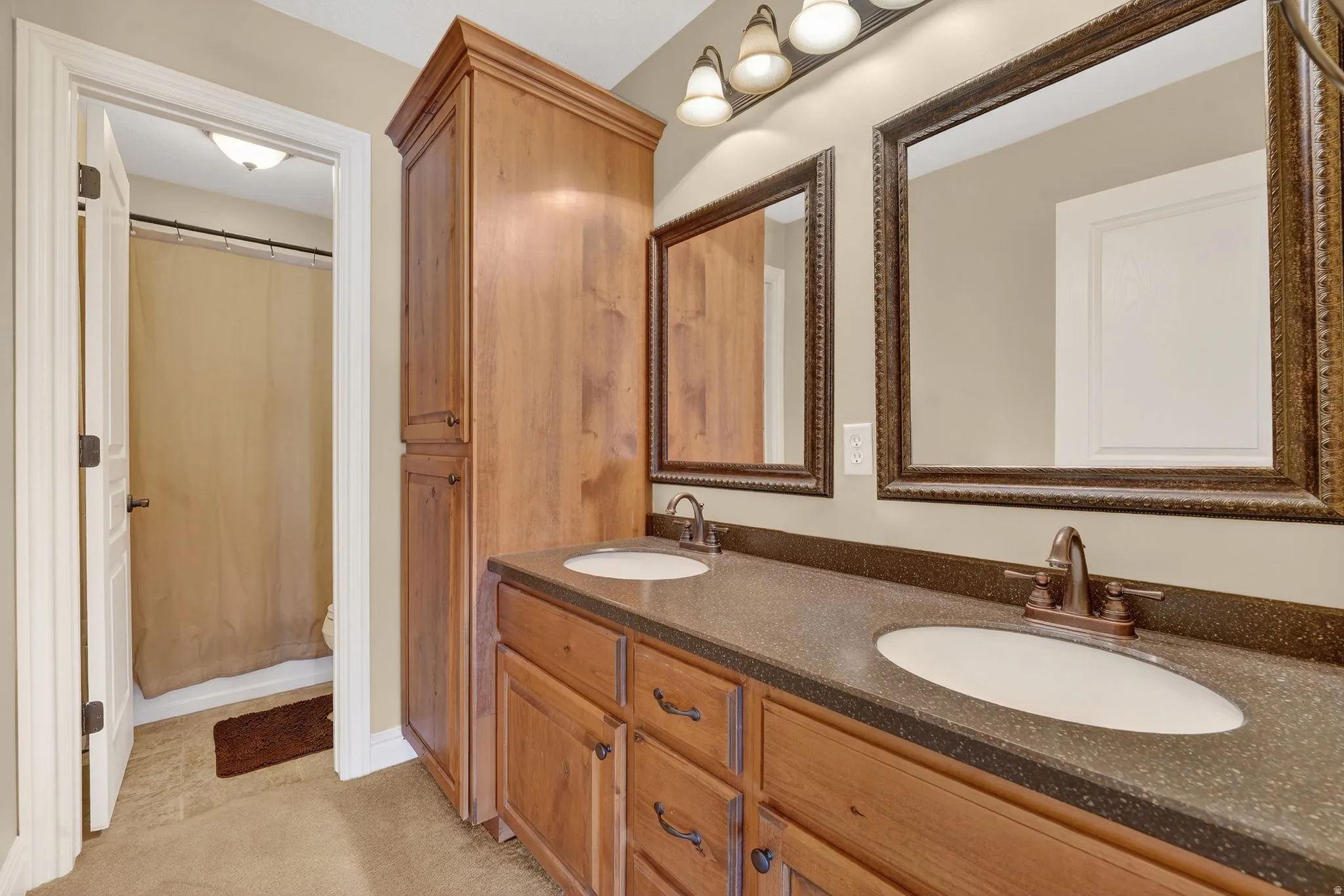 Bathroom featuring double vanity and a shower with shower curtain