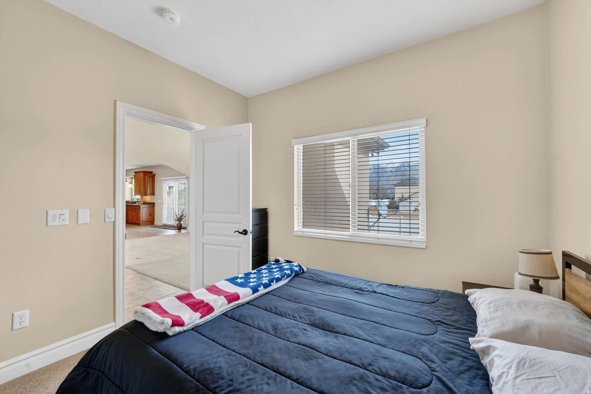 Bedroom with light colored carpet and arched walkways