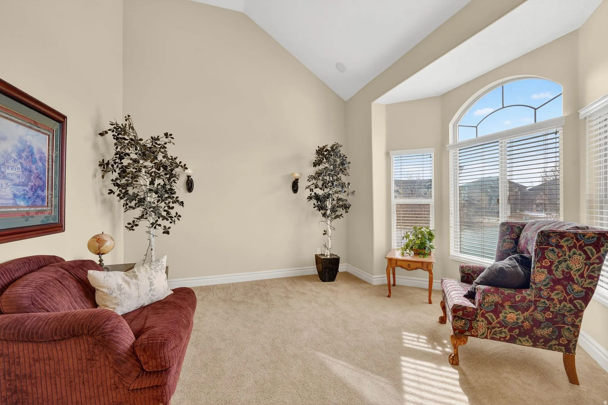 Living area with light carpet and lofted ceiling