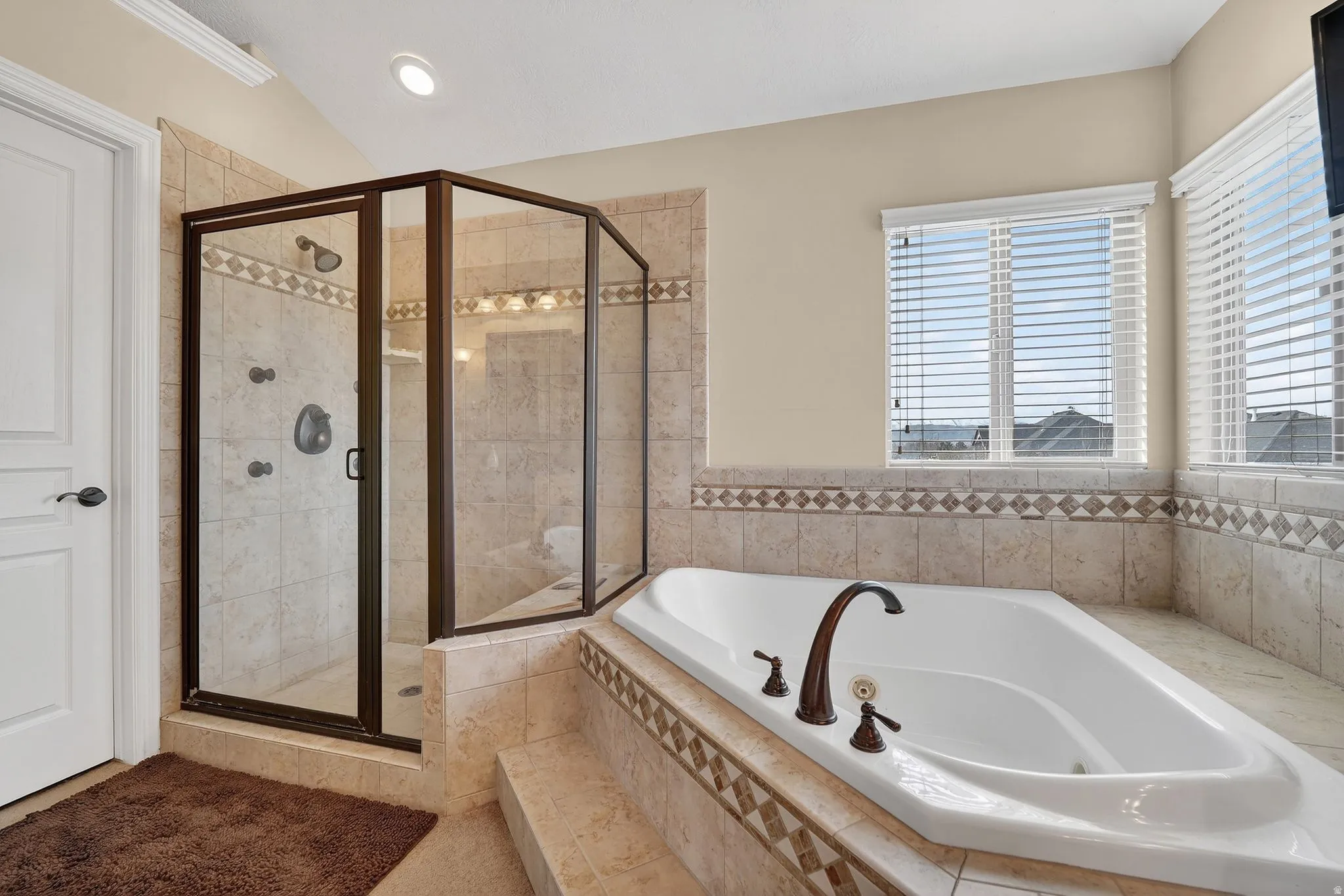 Full bathroom featuring a shower stall and a jetted tub