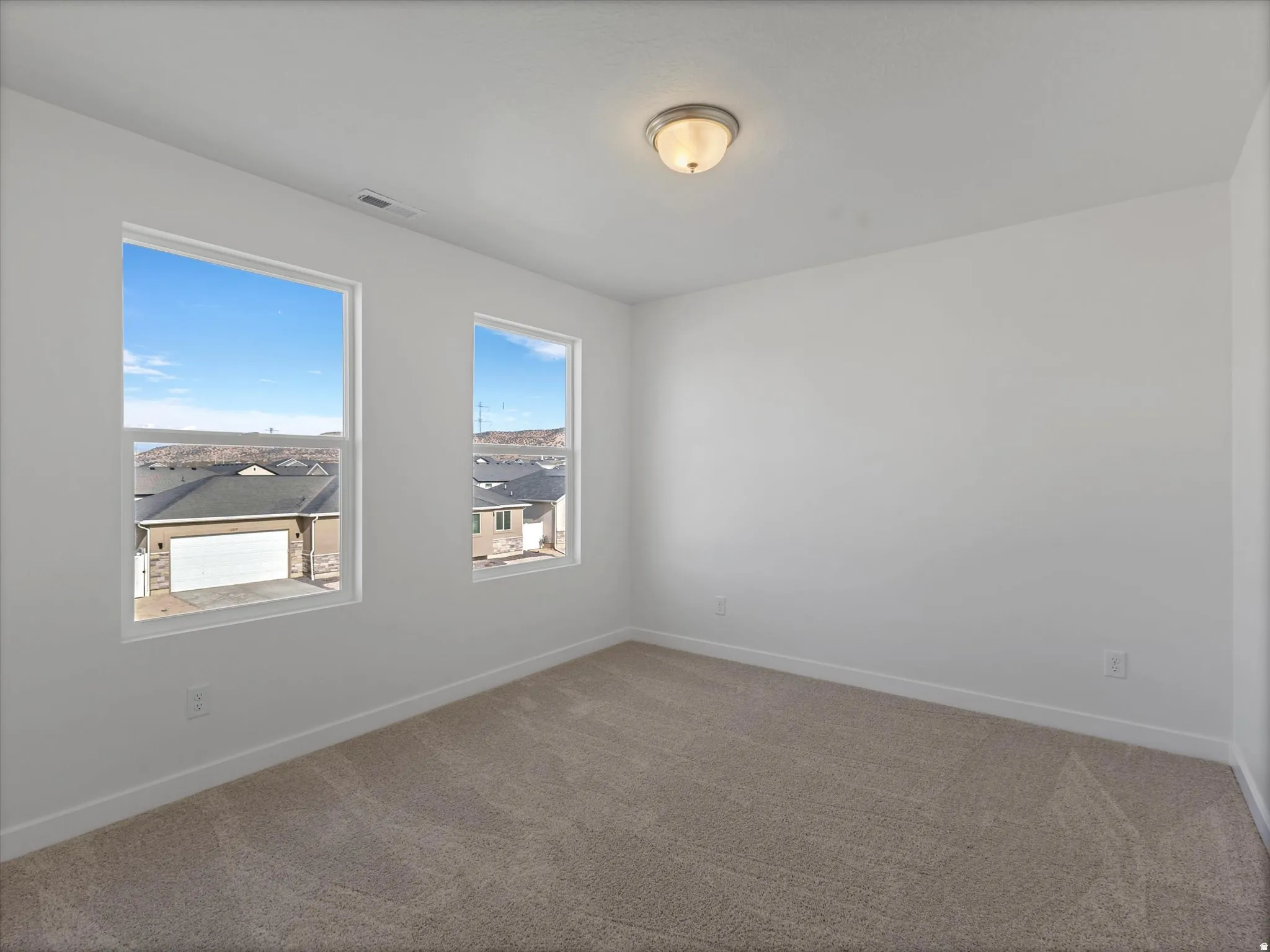 Empty room featuring carpet and baseboards