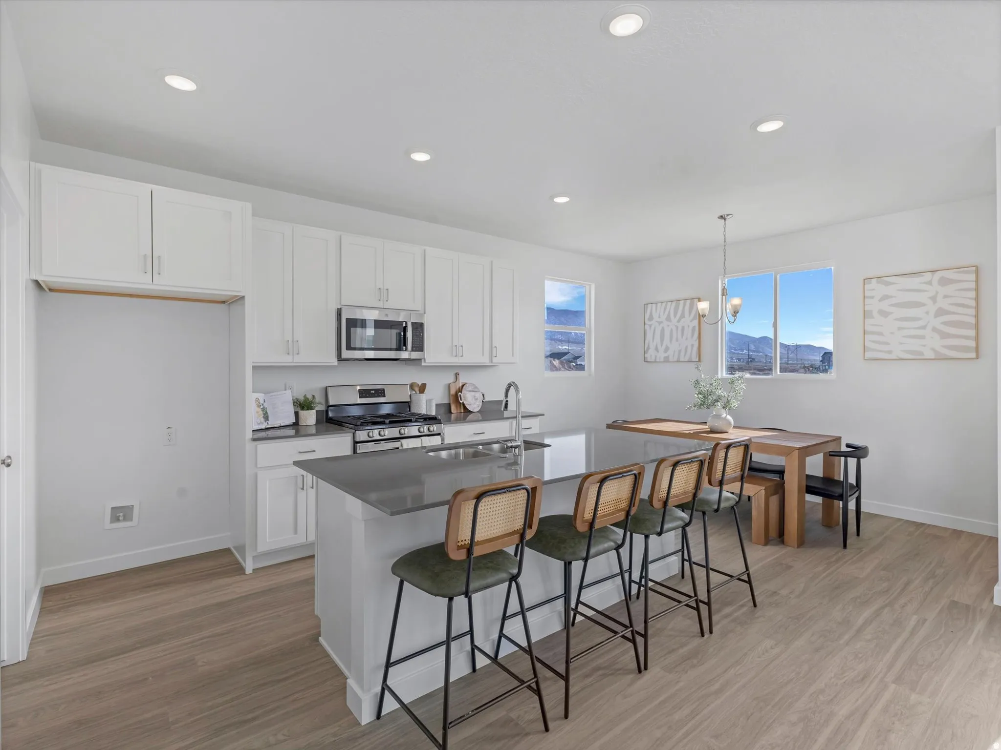 Kitchen with white cabinetry, stainless steel appliances, a kitchen bar, and light wood-style floors