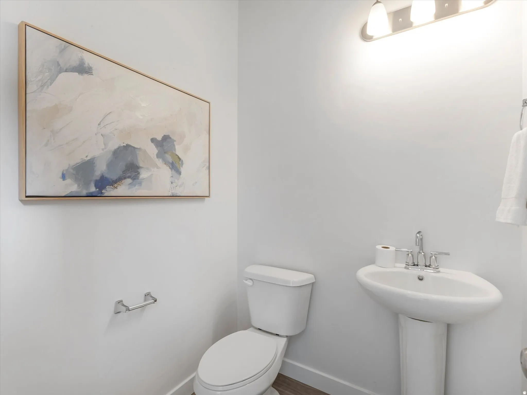 Half bath featuring toilet and baseboards