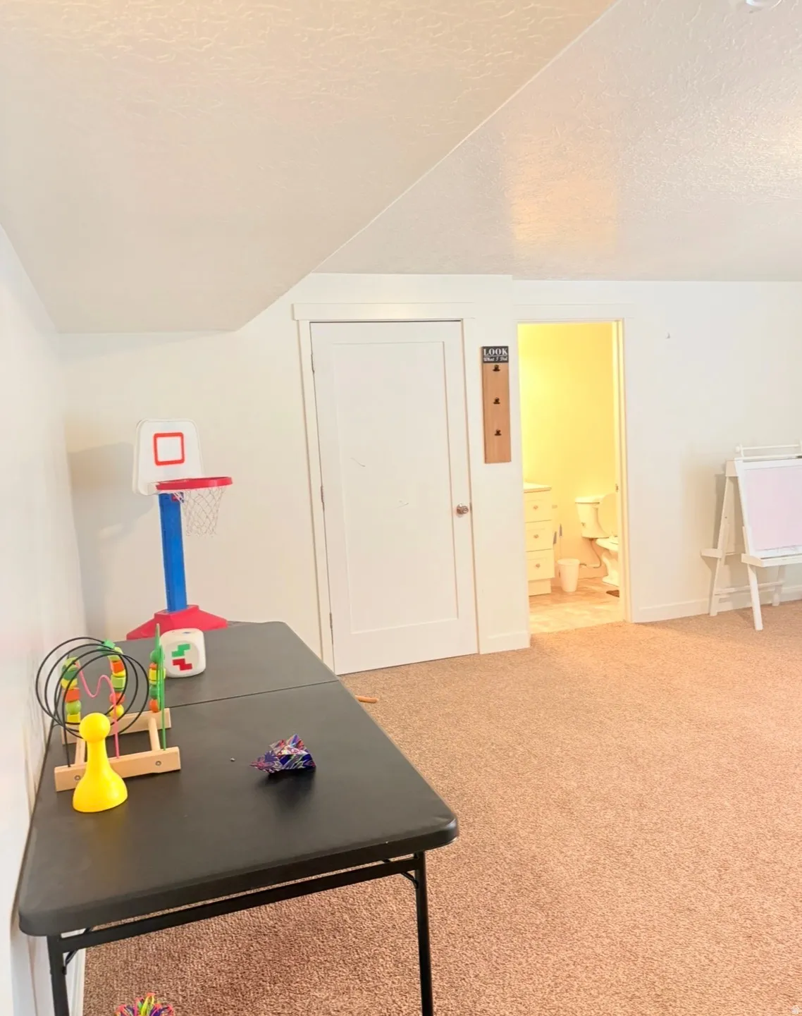 Recreation room featuring a textured ceiling and carpet floors