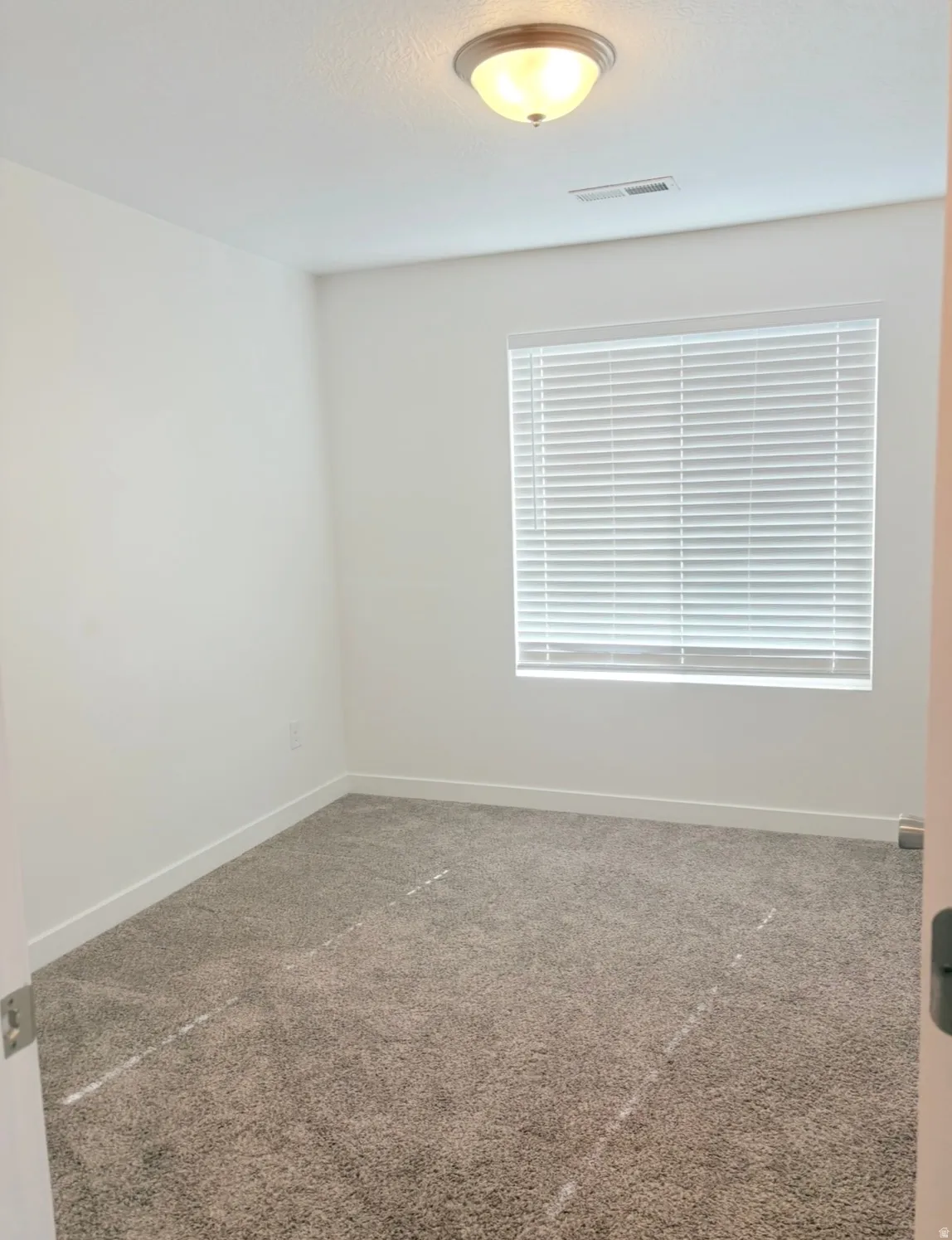 Empty room featuring dark carpet and baseboards