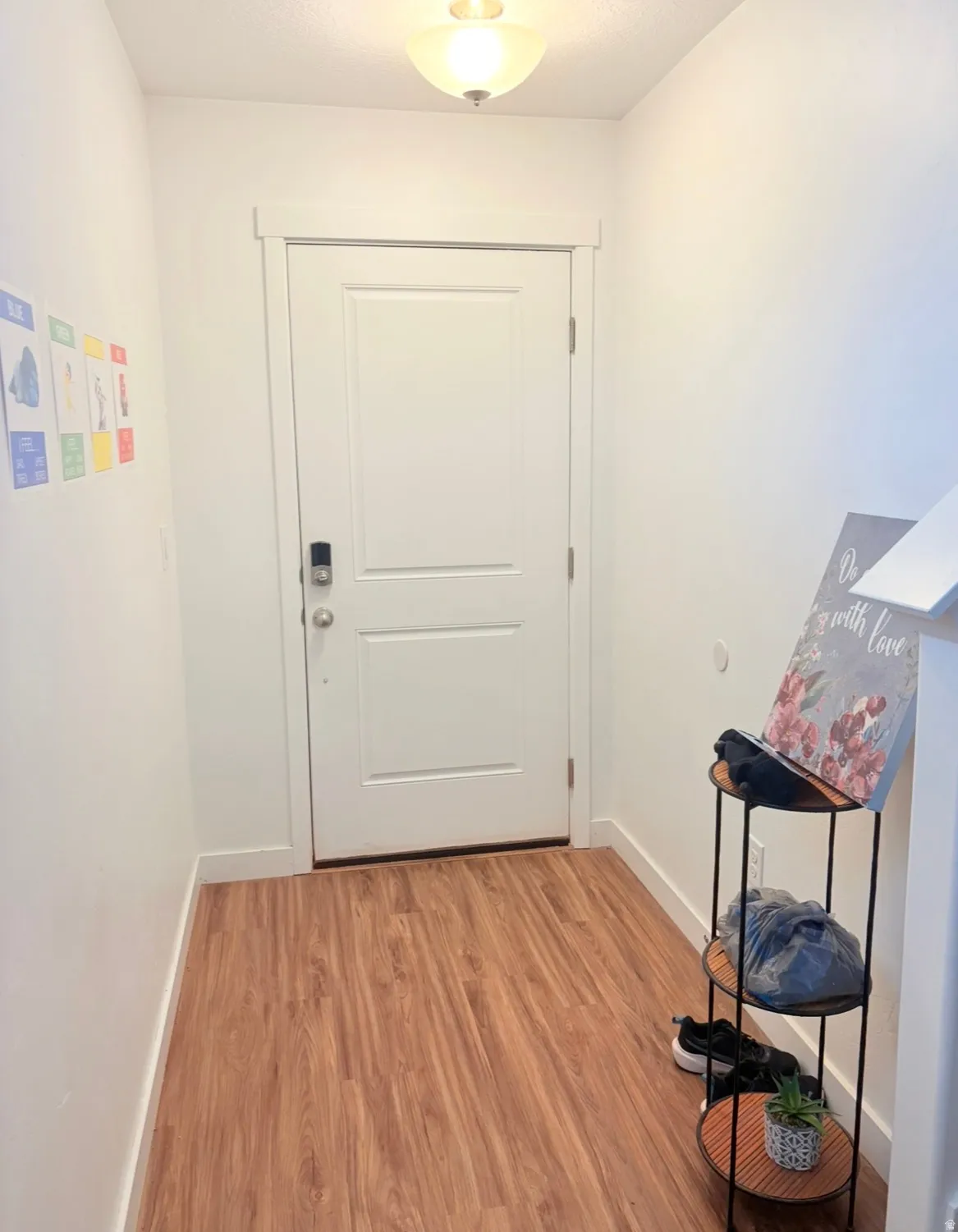 Doorway with baseboards and wood finished floors