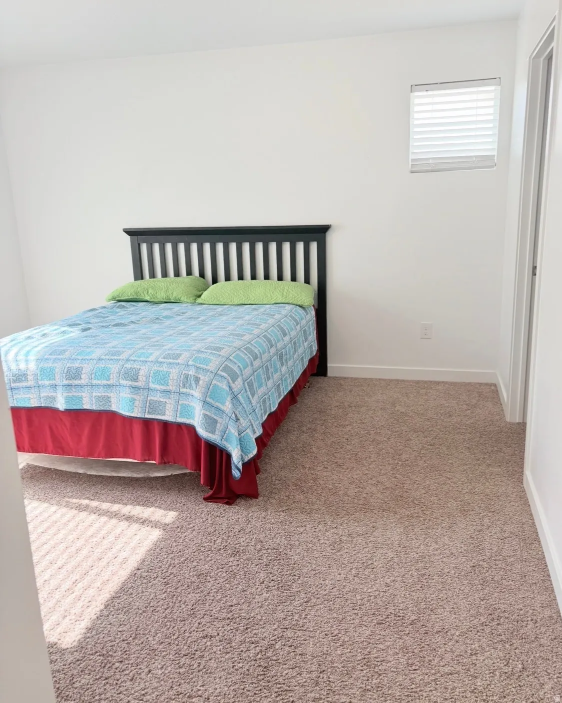 Bedroom featuring light carpet and baseboards