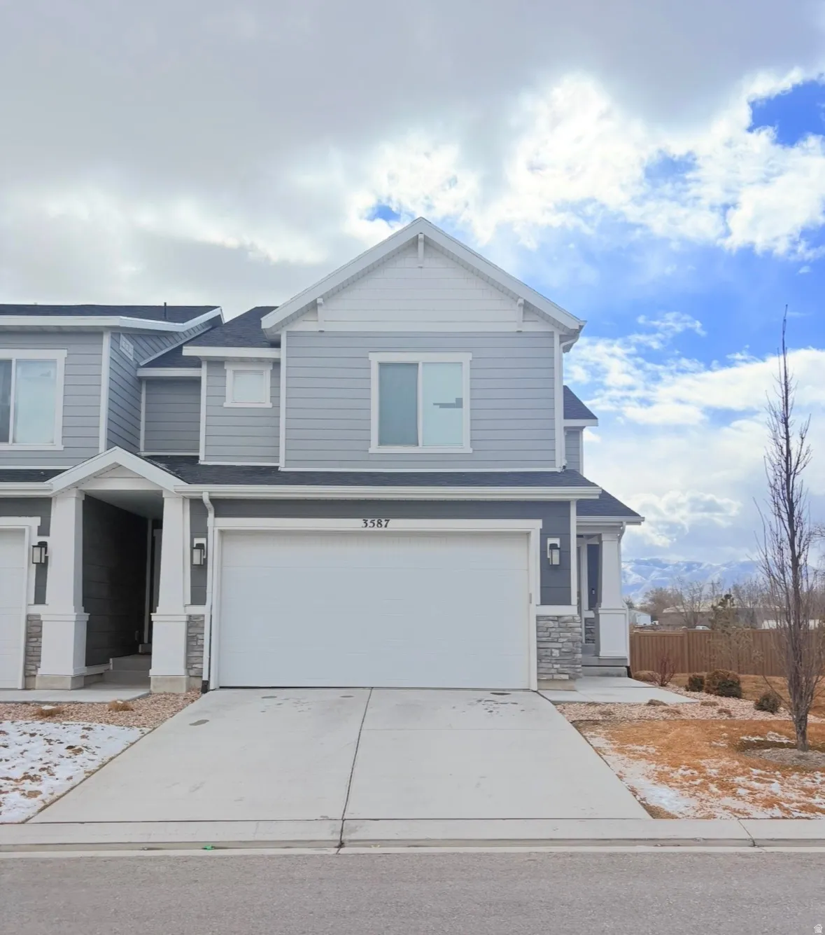 Craftsman-style house with stone siding, concrete driveway, and a garage