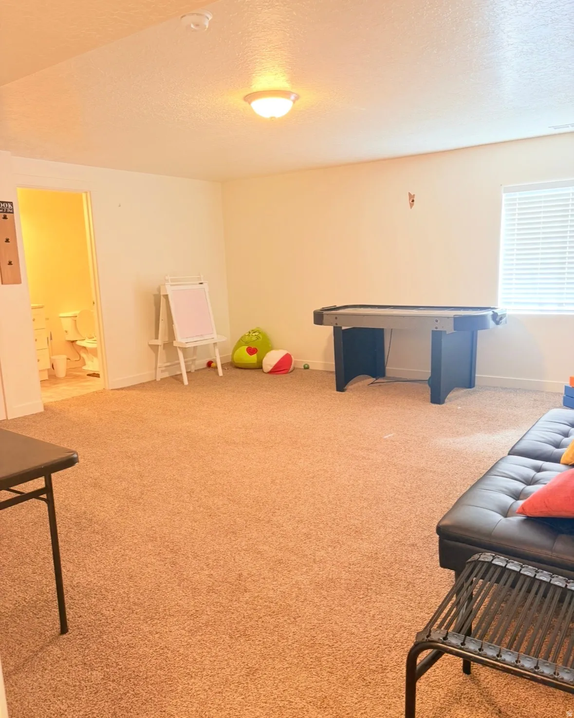 Playroom featuring a textured ceiling and light carpet