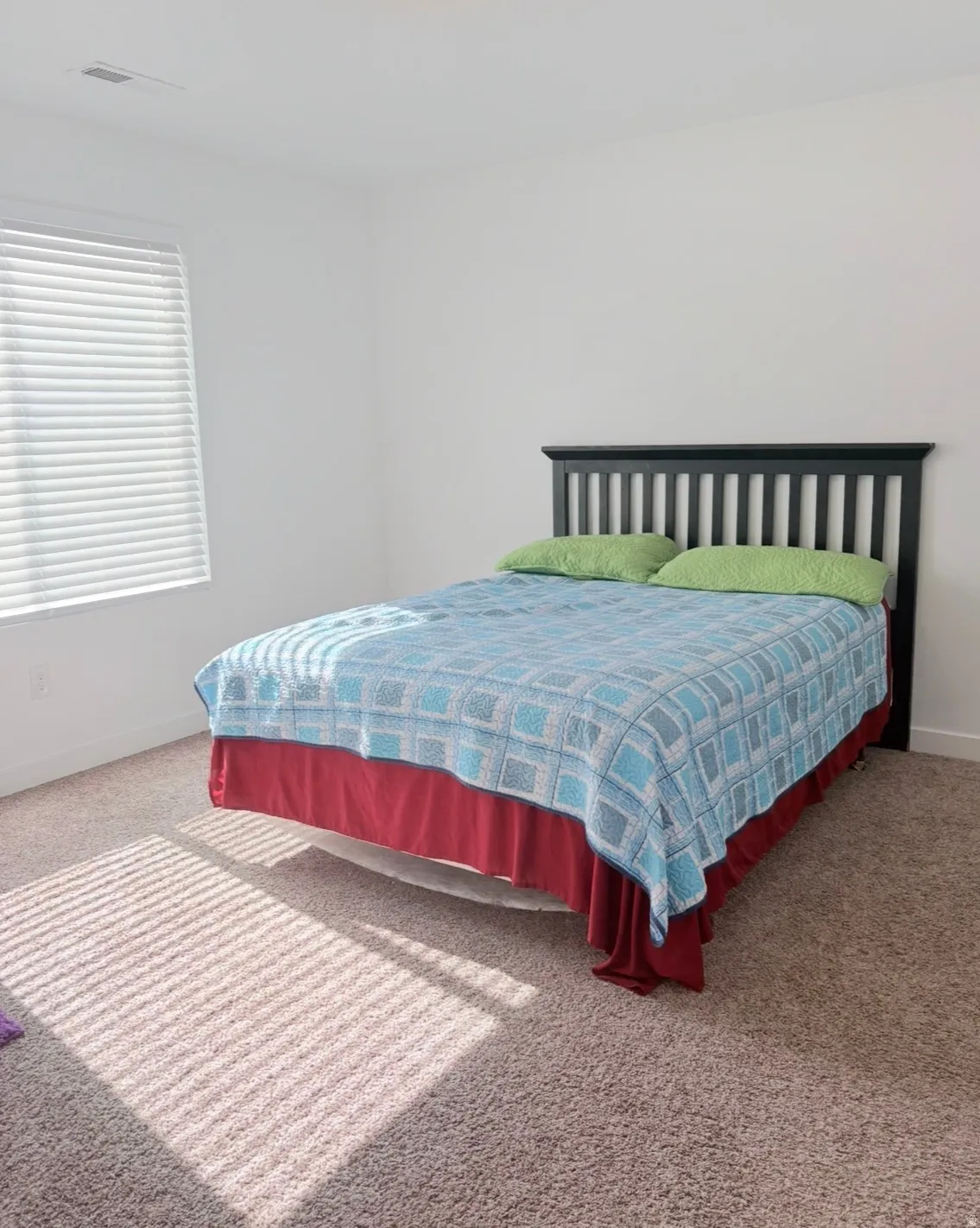 Bedroom featuring light carpet and baseboards