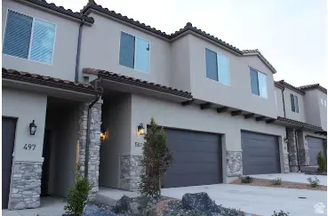 Mediterranean / spanish home with a garage, stone siding, and stucco siding