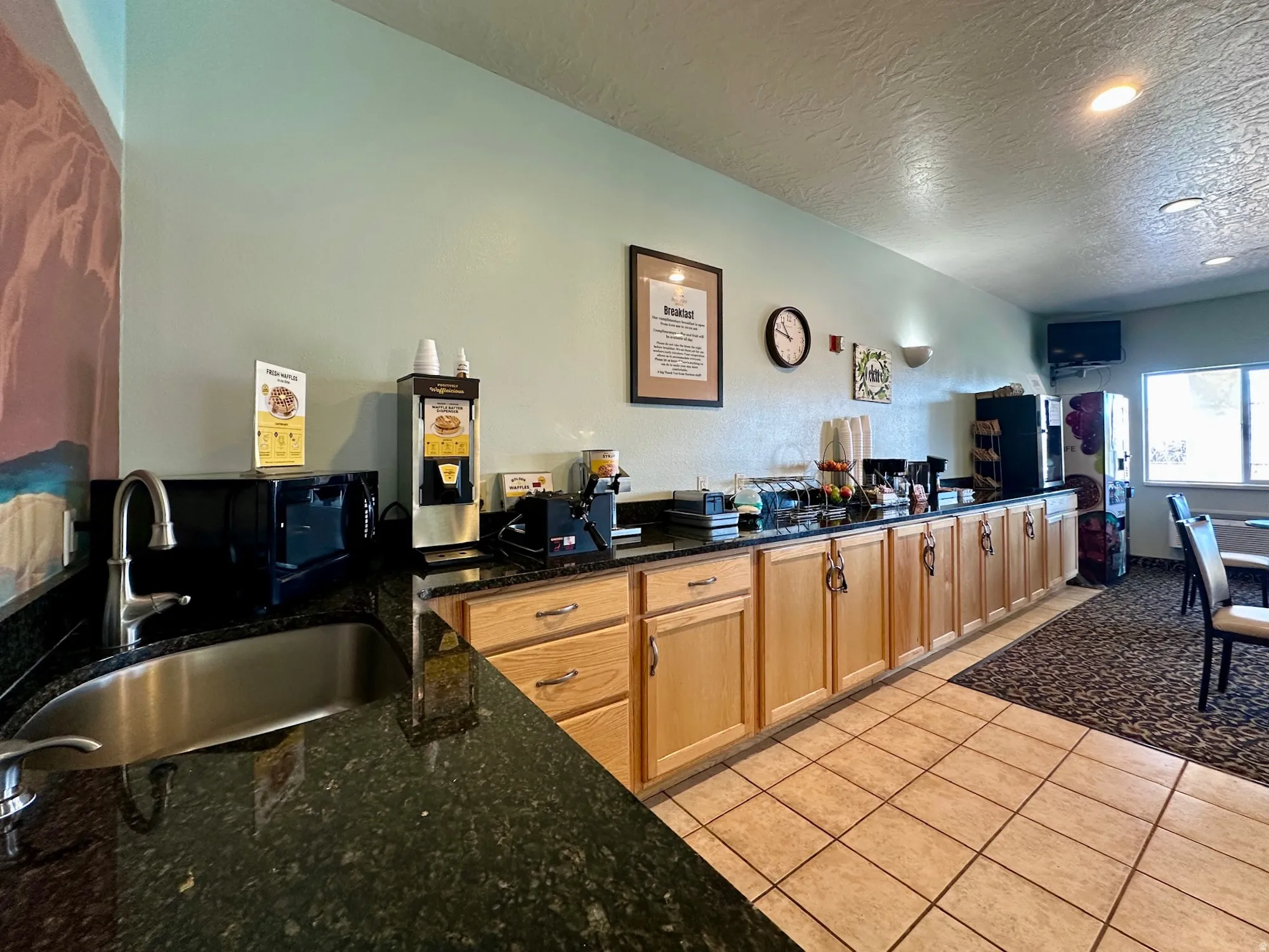 Kitchen featuring dark stone countertops, a textured ceiling, and light tile patterned flooring