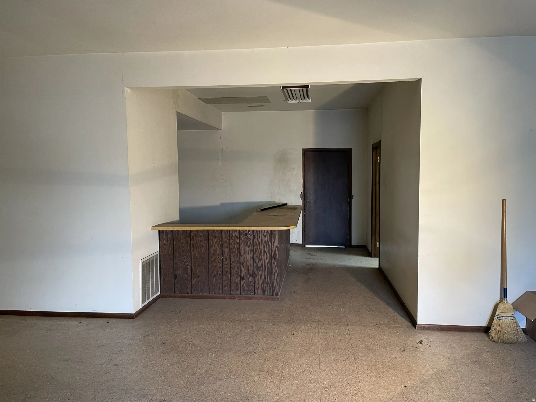 Corridor featuring light flooring and baseboards