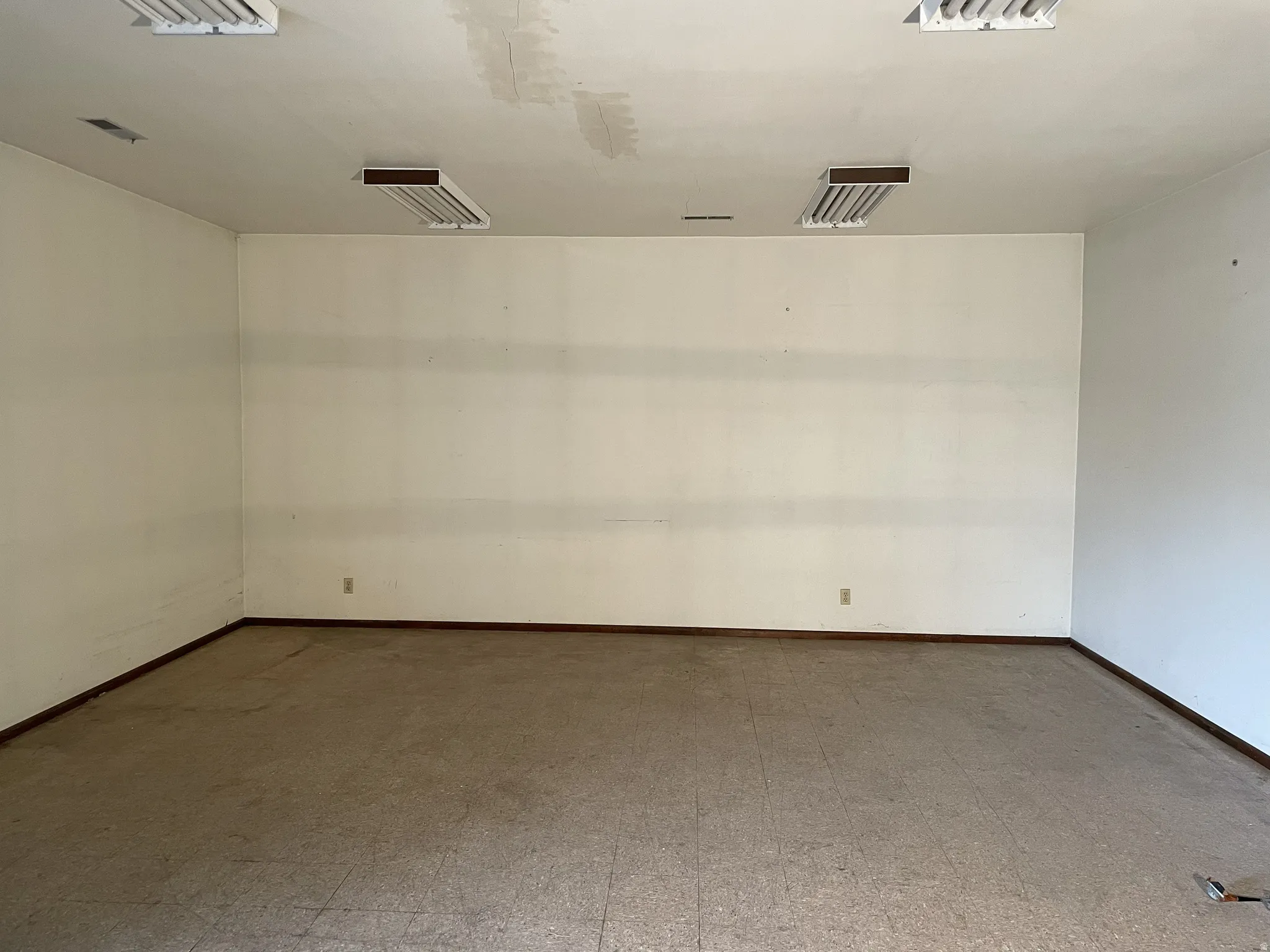 Empty room with tile patterned floors and baseboards