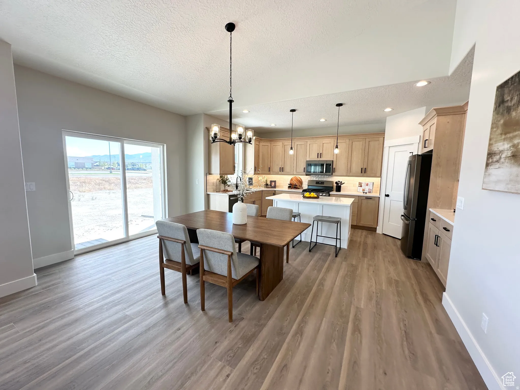 Dining room with hanging lights and light wood finished floors