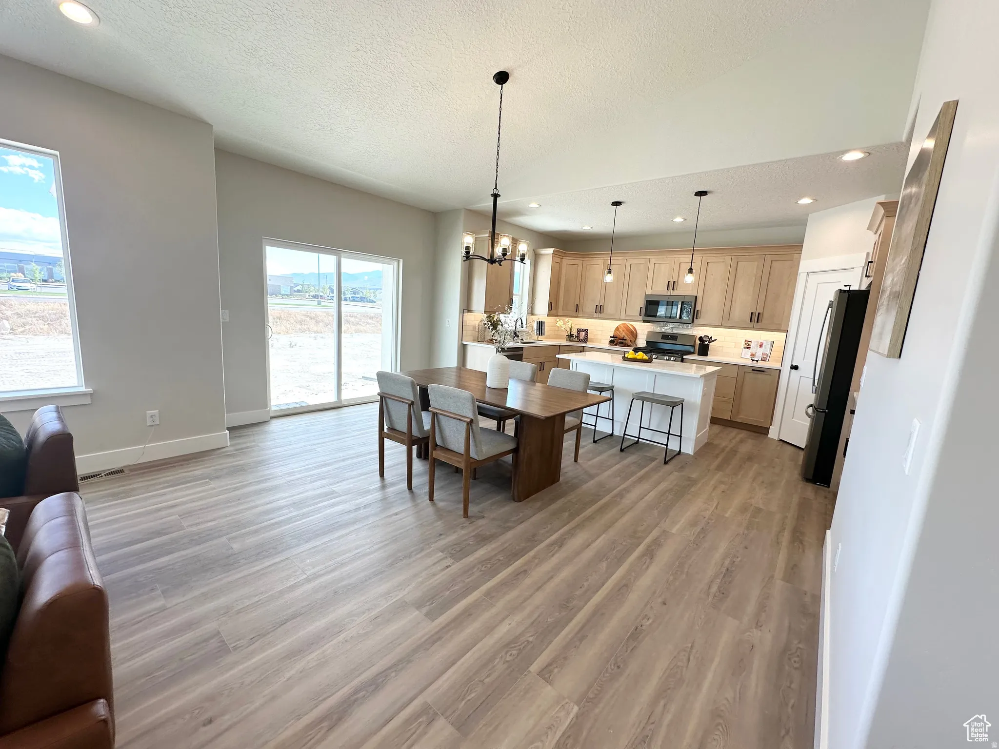 Dining space with hanging lights and light wood finished floors